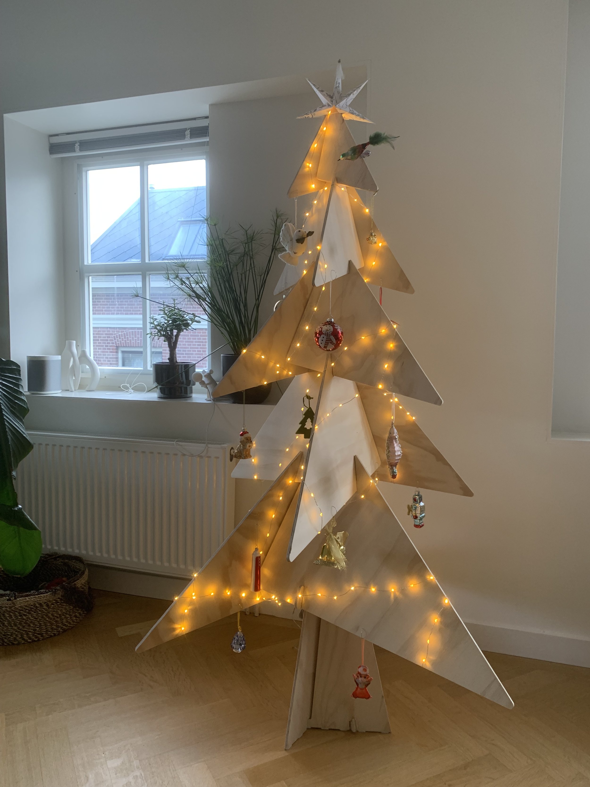 Houten Puzzelboom 160cm met verlichting en versiering bij klant thuis in appartement in Amsterdam