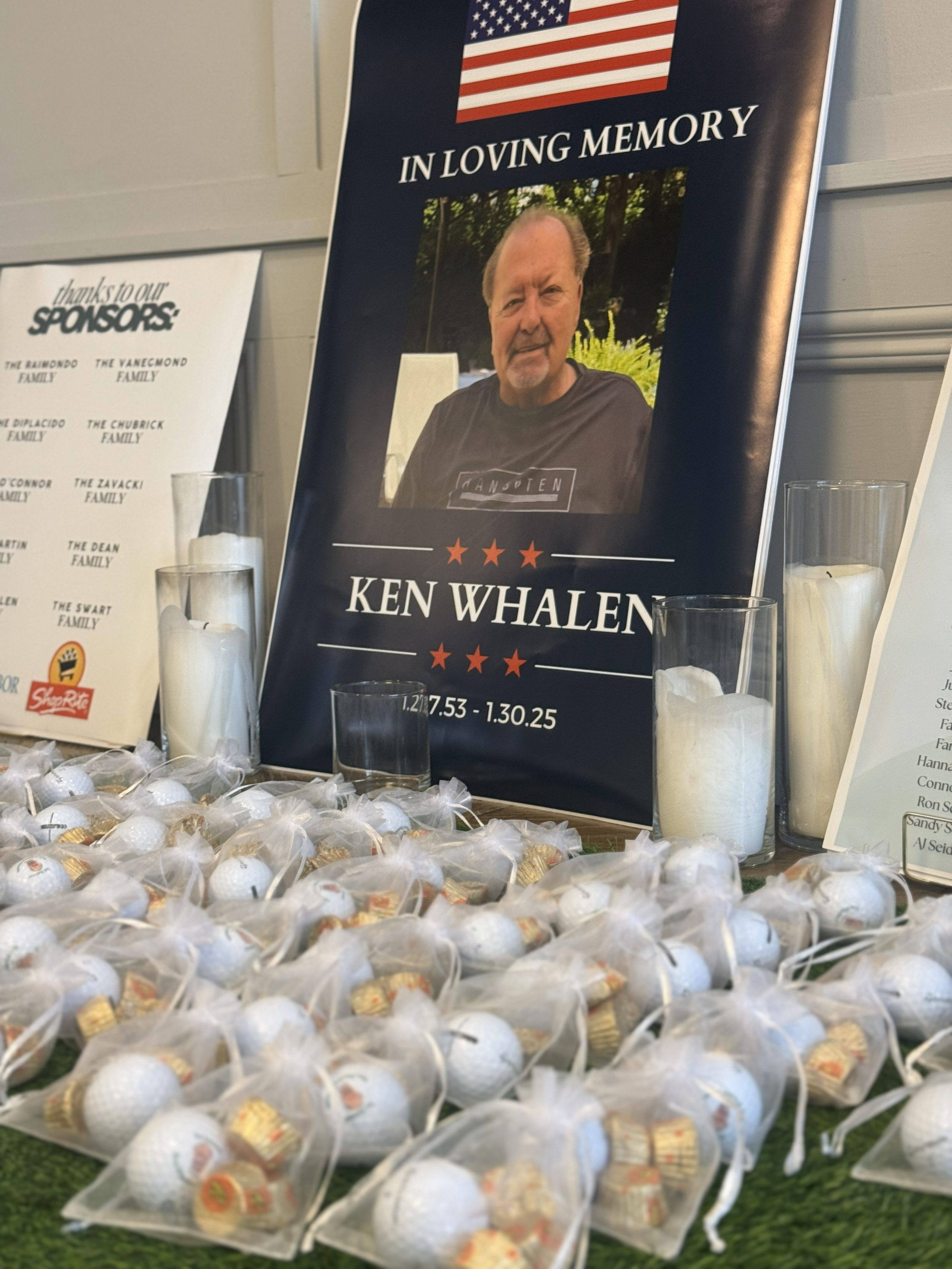 Memorial display with candles, and small bags of golf balls on a table.