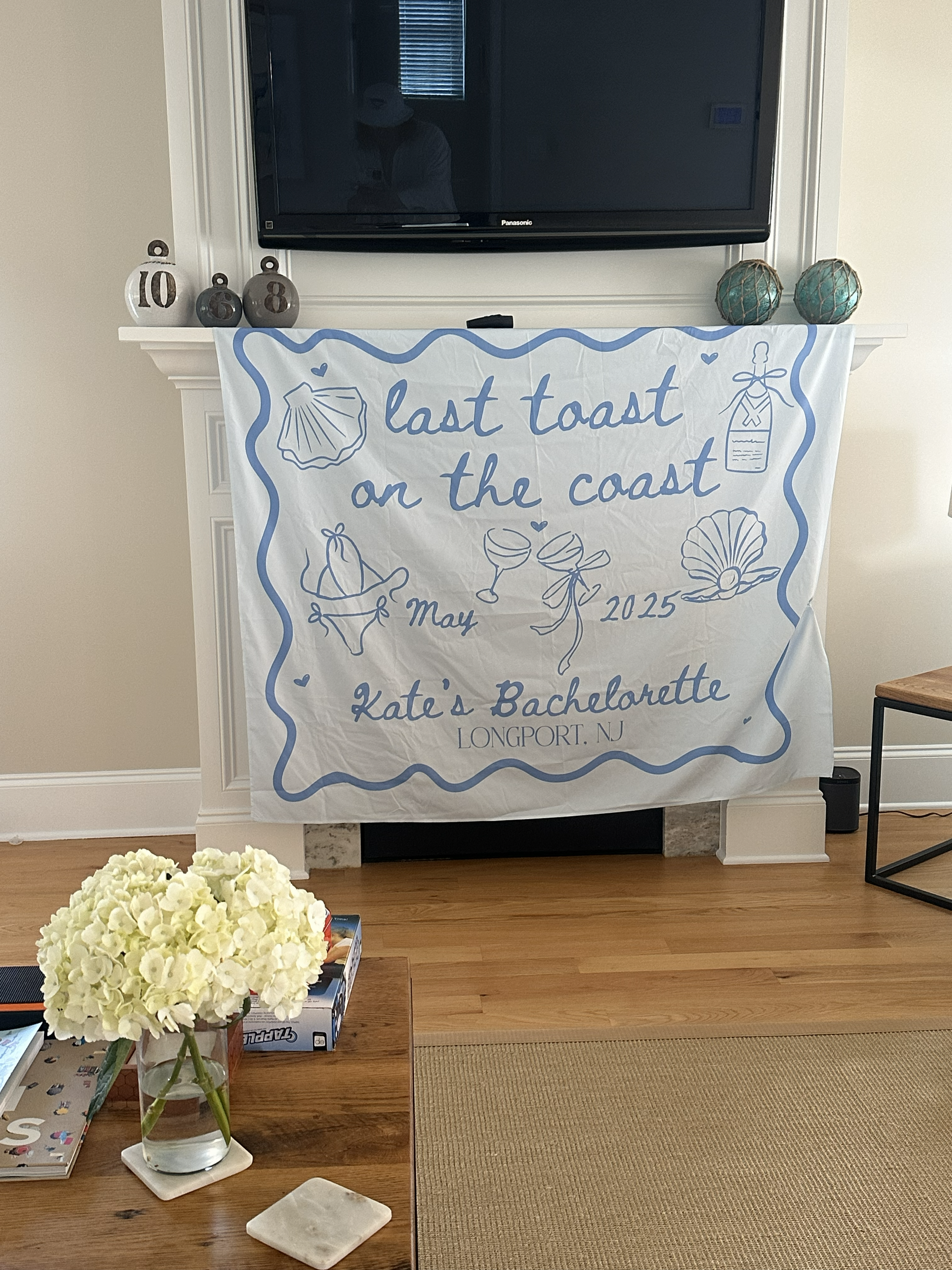 A decorative banner hanging on a fireplace for a bachelorette party.