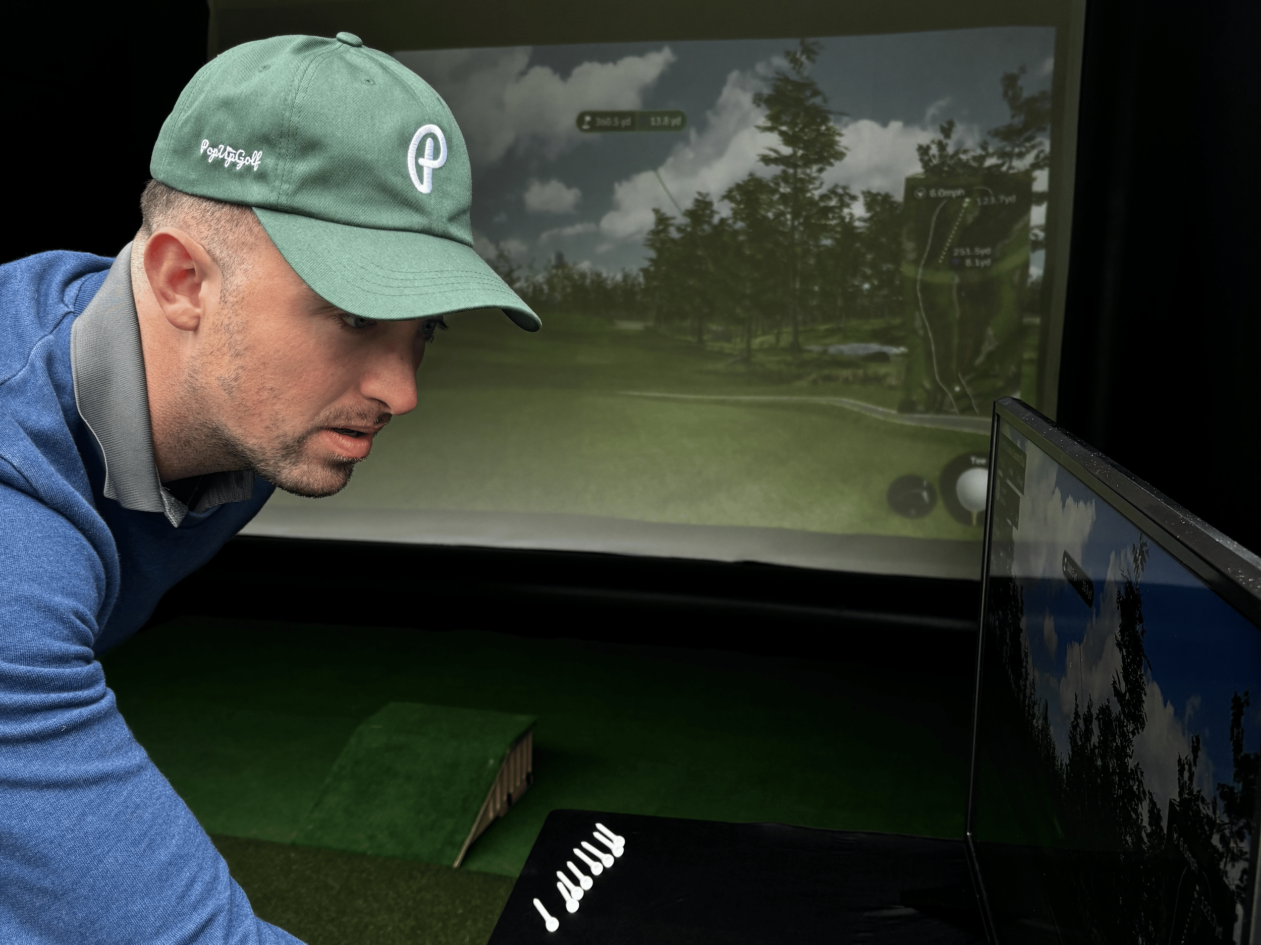 Golfer adjusting aim on sim