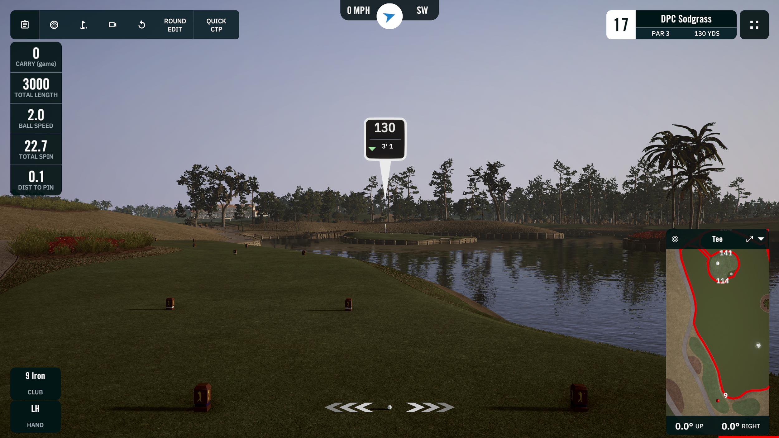 Golf course tee box overlooking water, the famous par 3 at TPC Sawgrass with trees and a small bridge in the background, and a digital display showing yardage of 130 yards for the hole.