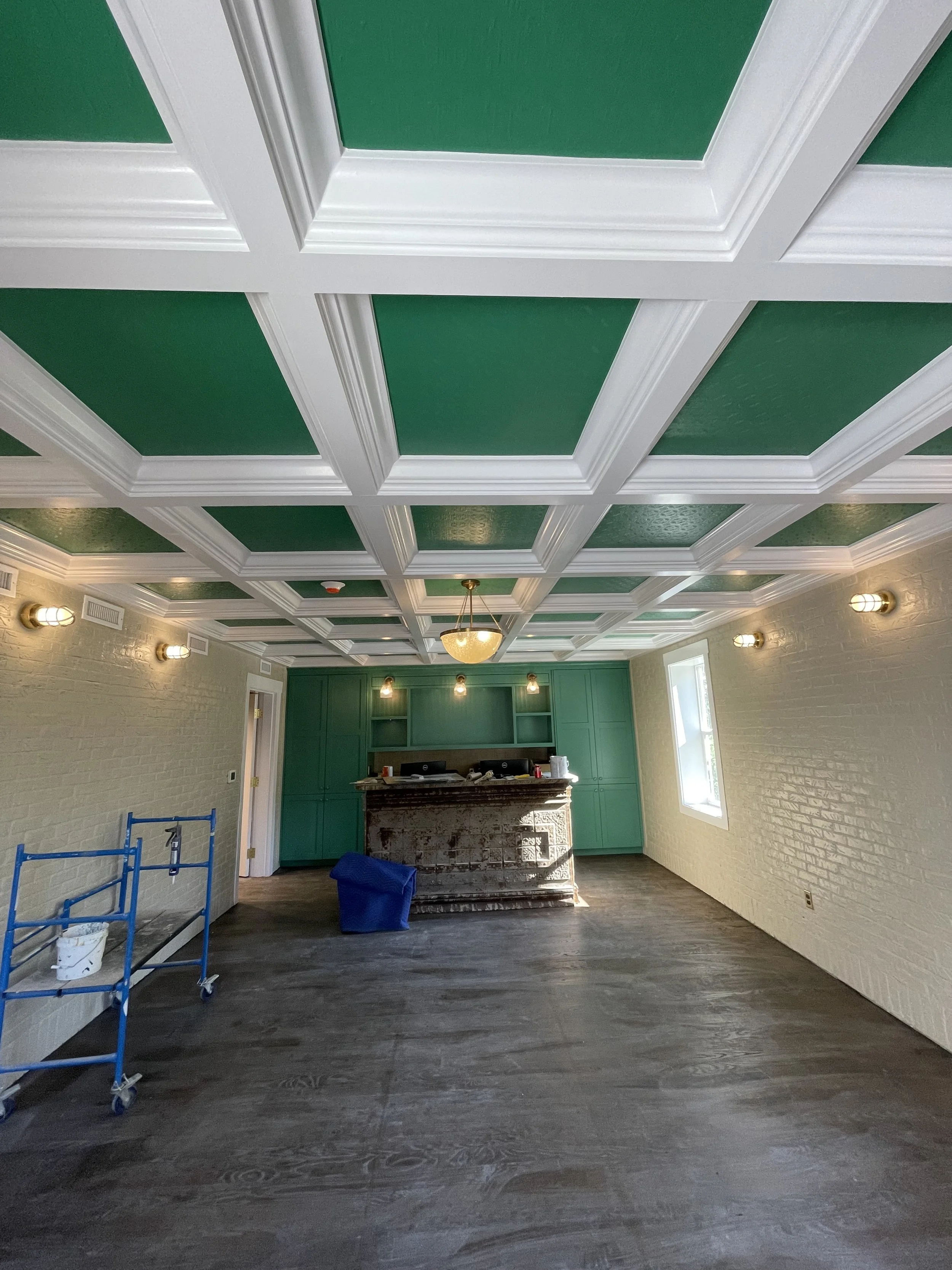 Brick painting with detailed coffered ceiling trim and painted accents in a boutique hotel