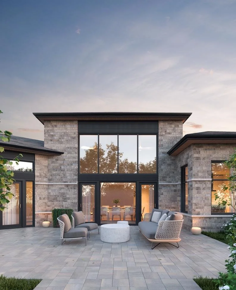 Modern house with large glass windows and patio furniture outside during sunset.