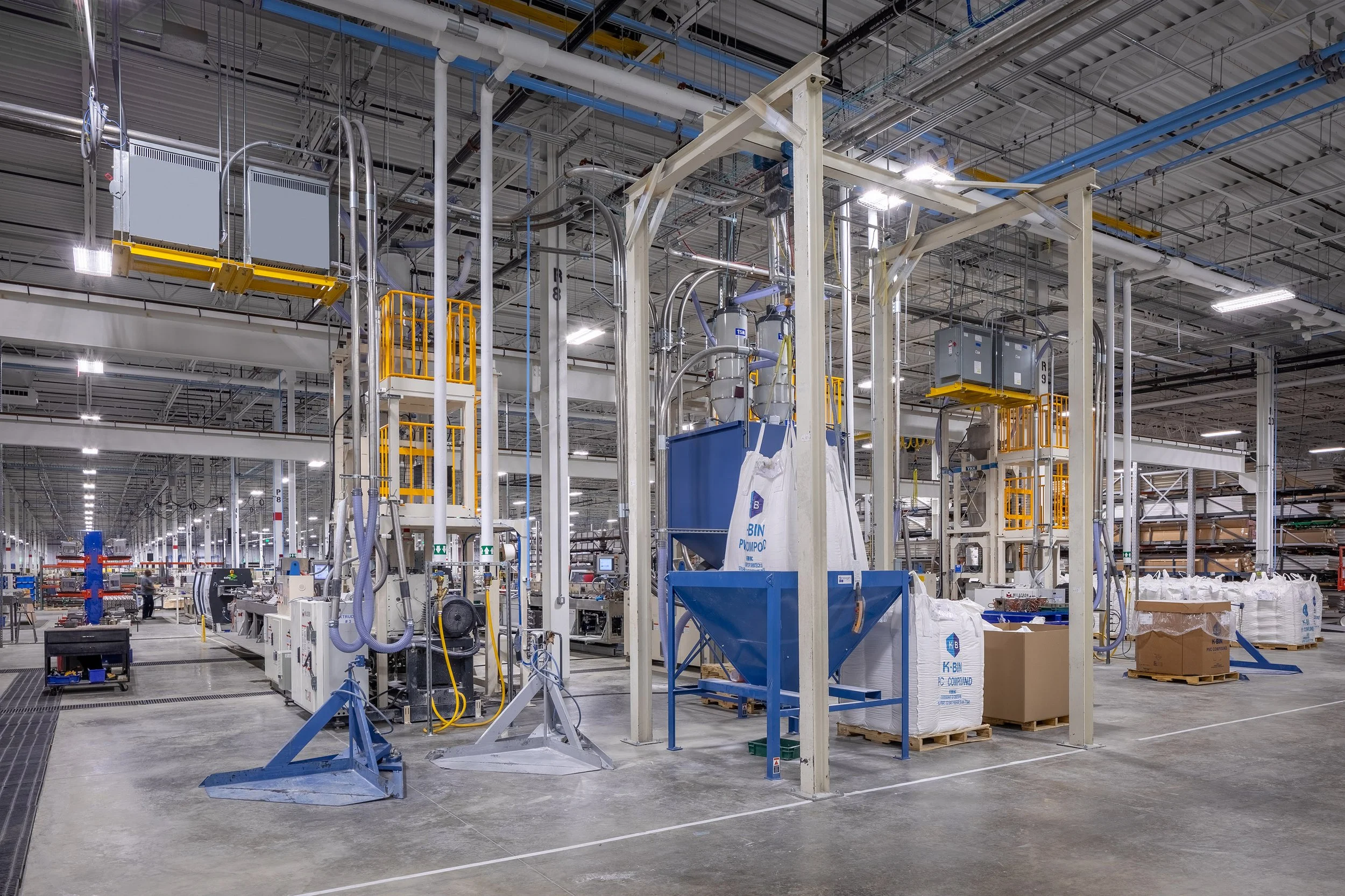 Modern factory interior in Macon with industrial equipment, automation systems, and large bags of raw materials on the floor.