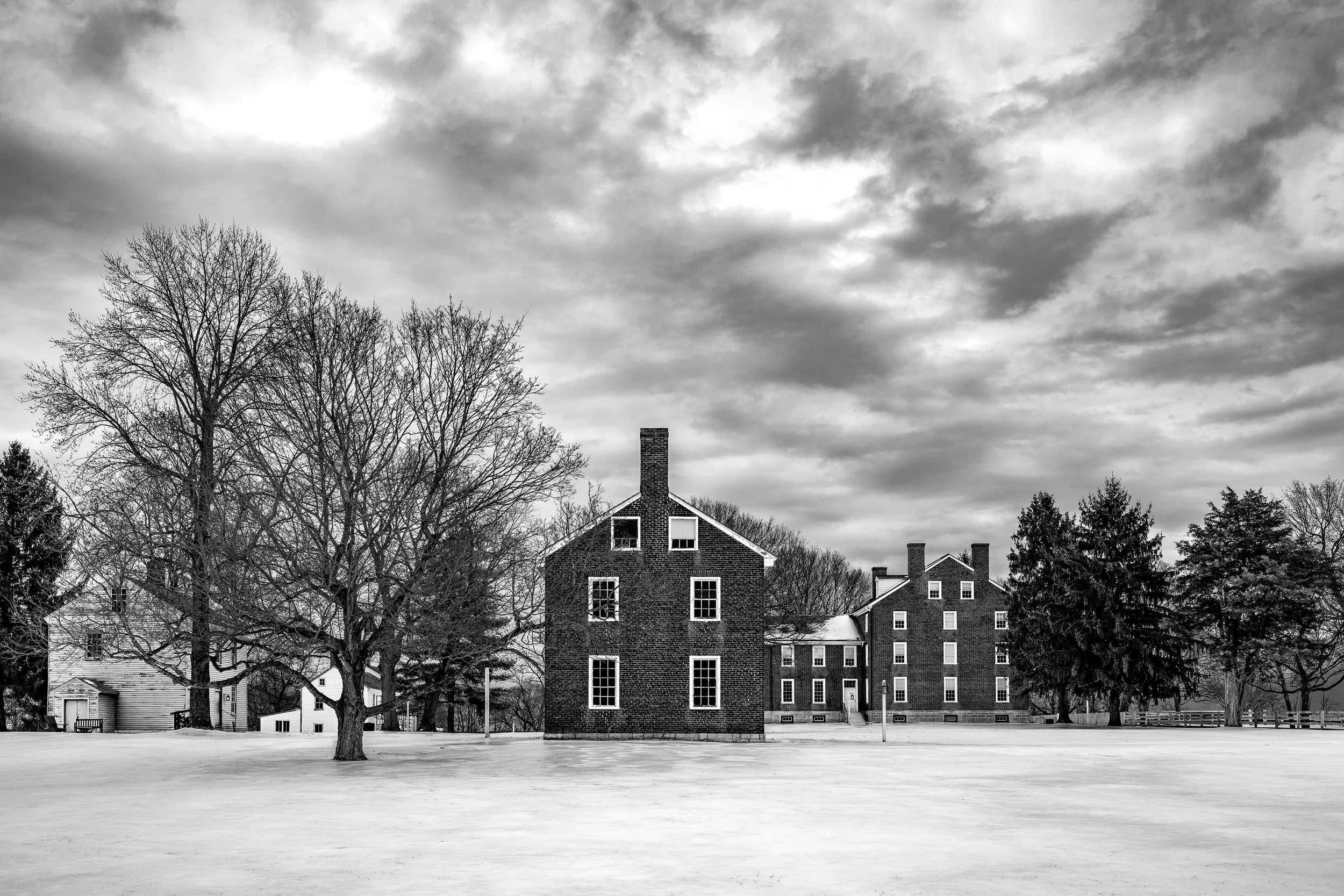 Shaker architecture in snow covered winter setting with striking clouds above.