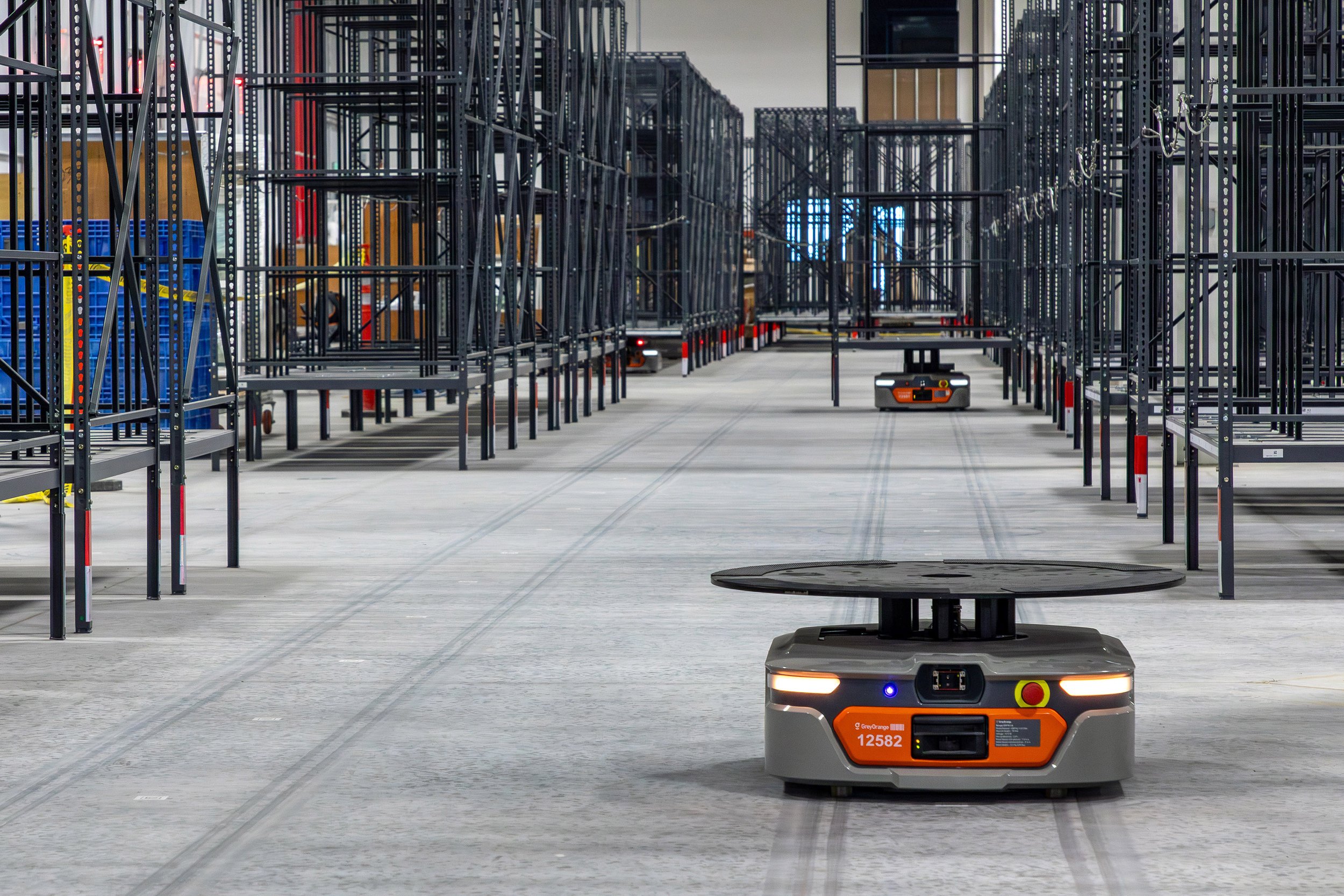 Robots navigate spacious aisles in a Georgia manufacturer’s automated warehouse, moving along guides on the concrete floor.