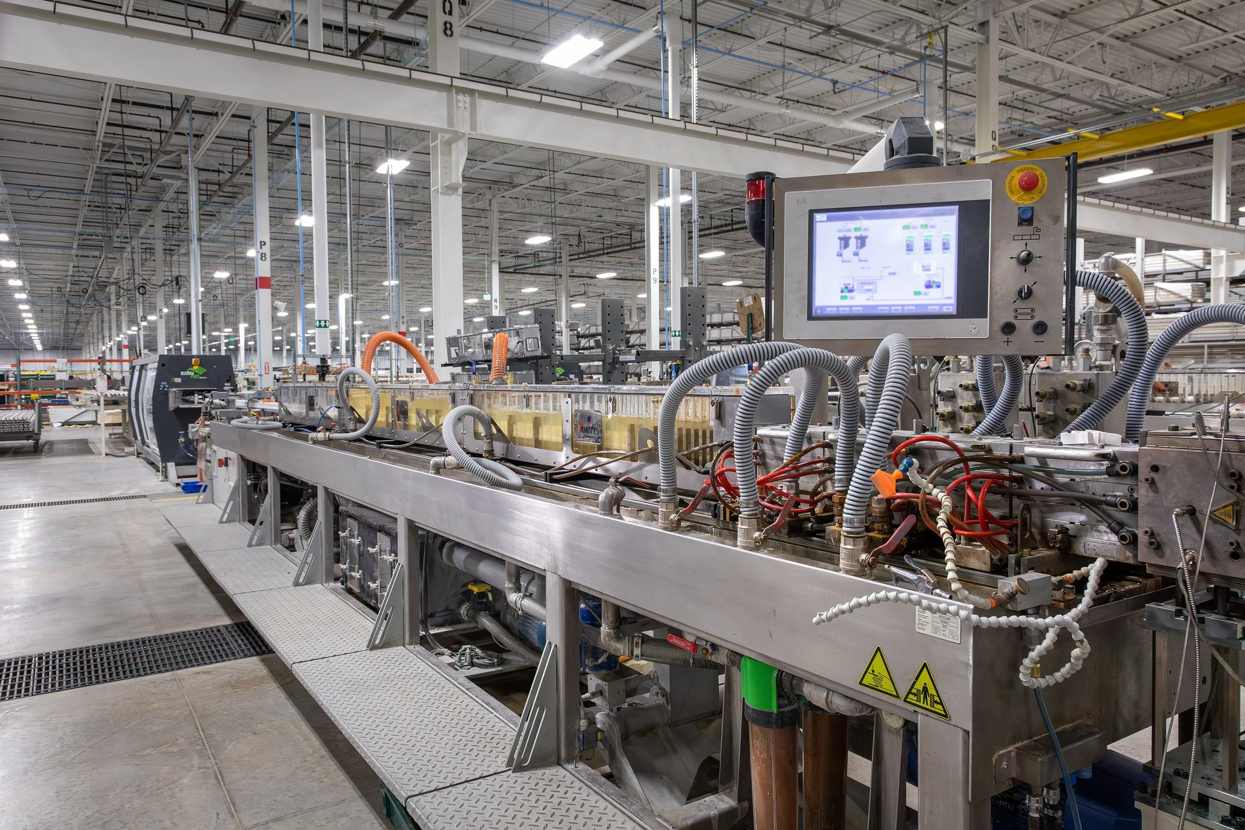 Industrial factory floor in Macon, Georgia, features automated machinery and a digital control panel in a modern, well-lit facility.