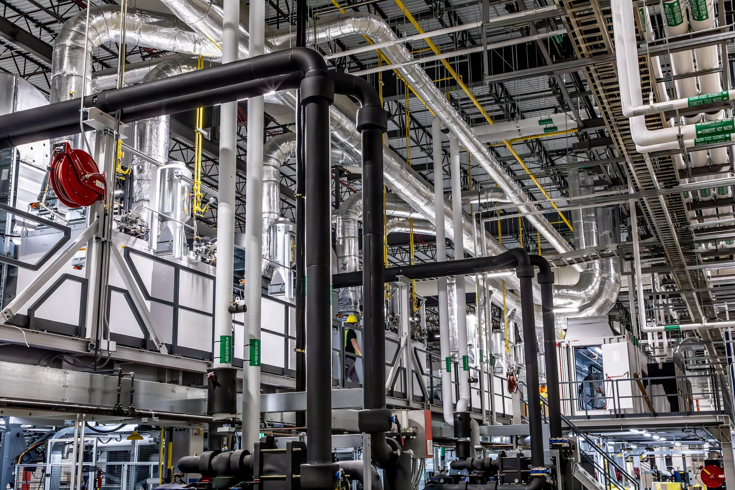An industrial facility interior, with metal pipes and ducts, reflects Georgia Pacific’s complex network of machinery and utilities.