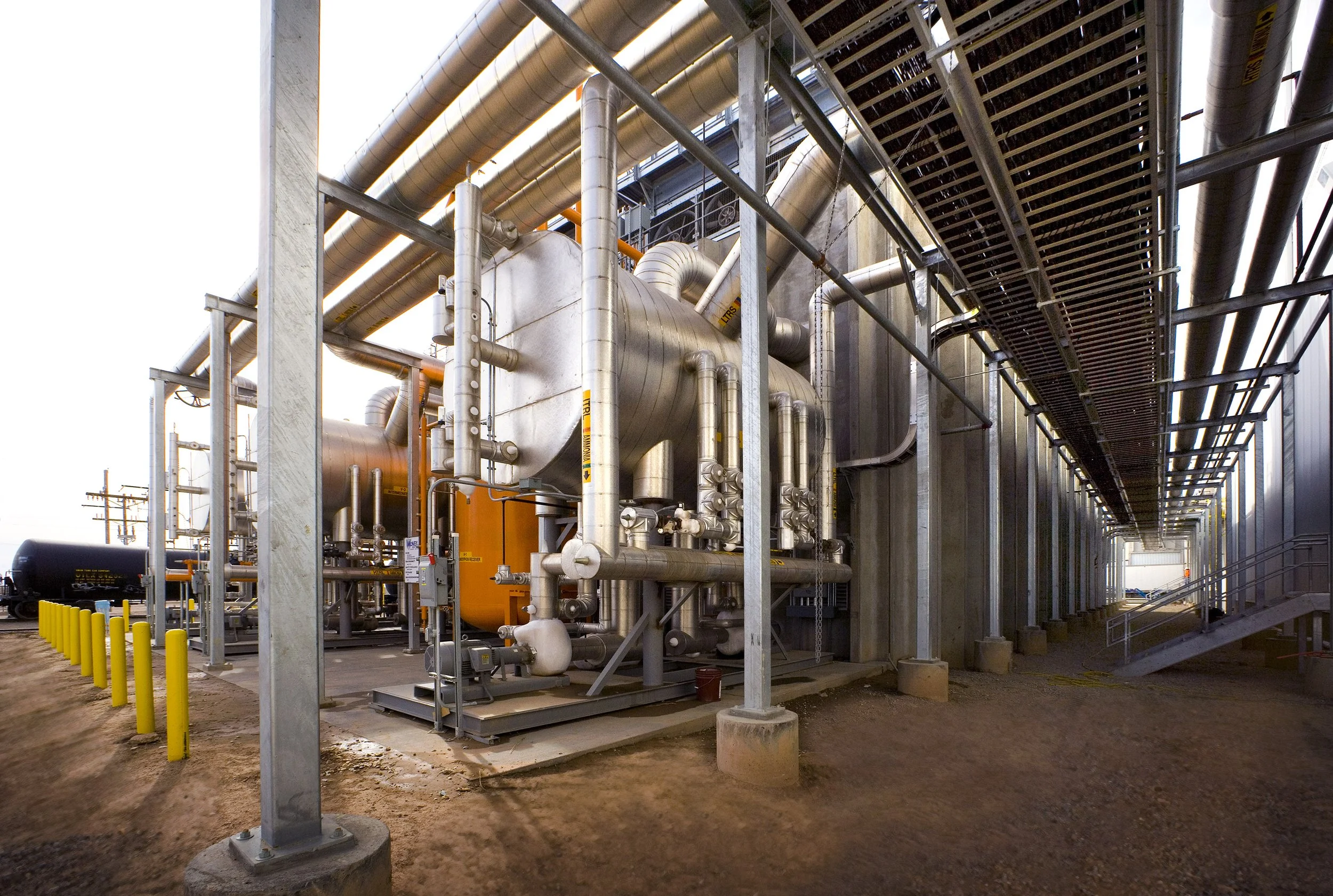 Industrial facility in Texas with large metal pipes, tanks, and support structures, captured through striking industrial photography.
