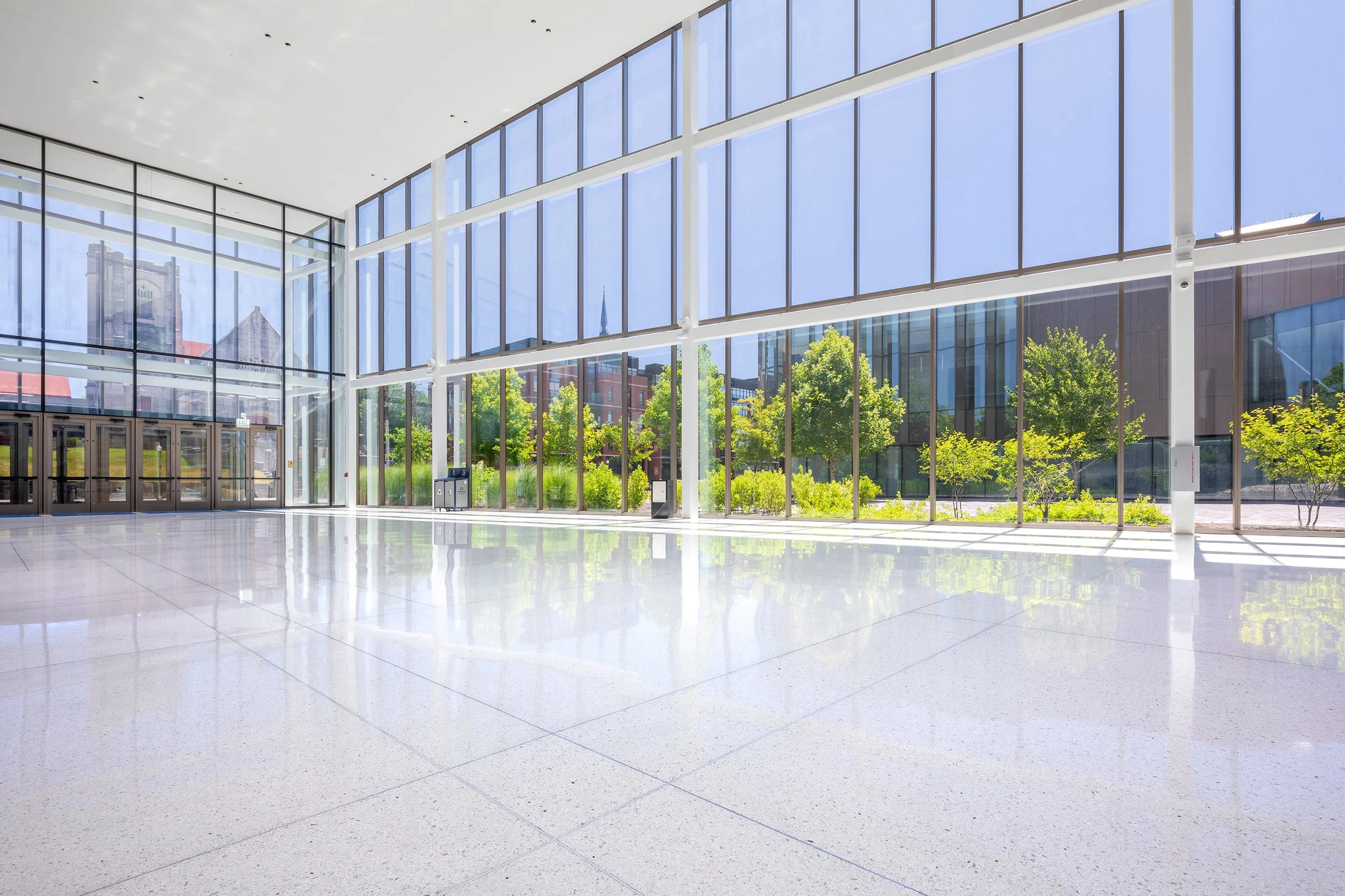 Spacious modern lobby at Central Bank Center with terrazzo floors, floor-to-ceiling windows, and outdoor greenery—just steps from Rupp Arena.