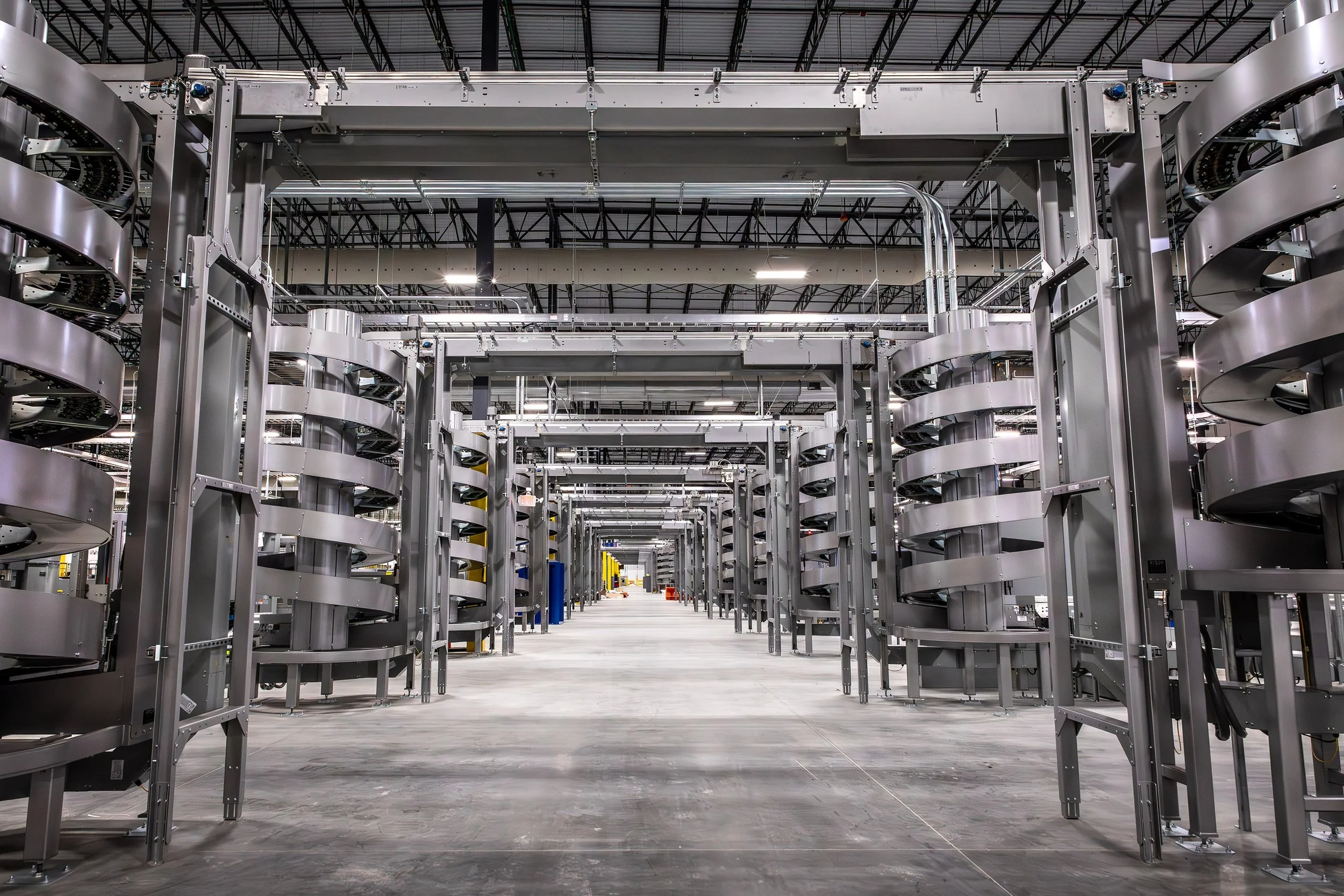 Rows of large, spiral conveyor systems in a spacious, industrial Georgia Pacific warehouse with a high ceiling and bright lighting.