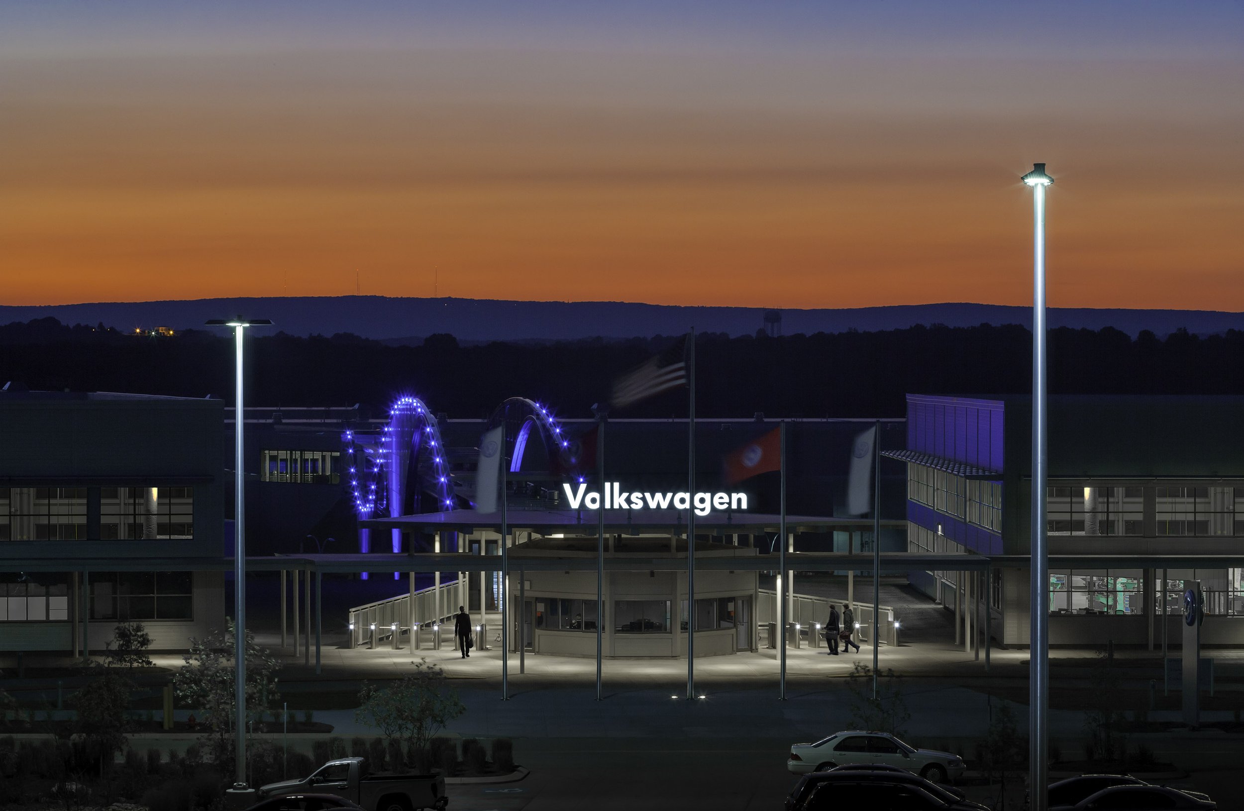Volkswagen Corporate building at dusk with illuminated signs and lights in the background.