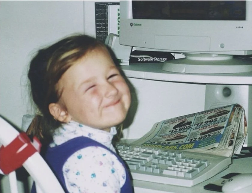 young girl smiling sitting at computer