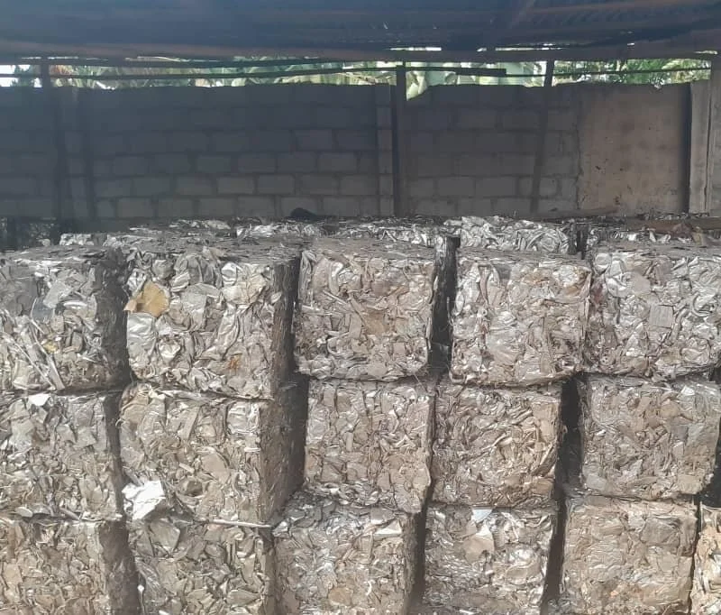 Baled crushed aluminum cans stacked in an indoor storage area.