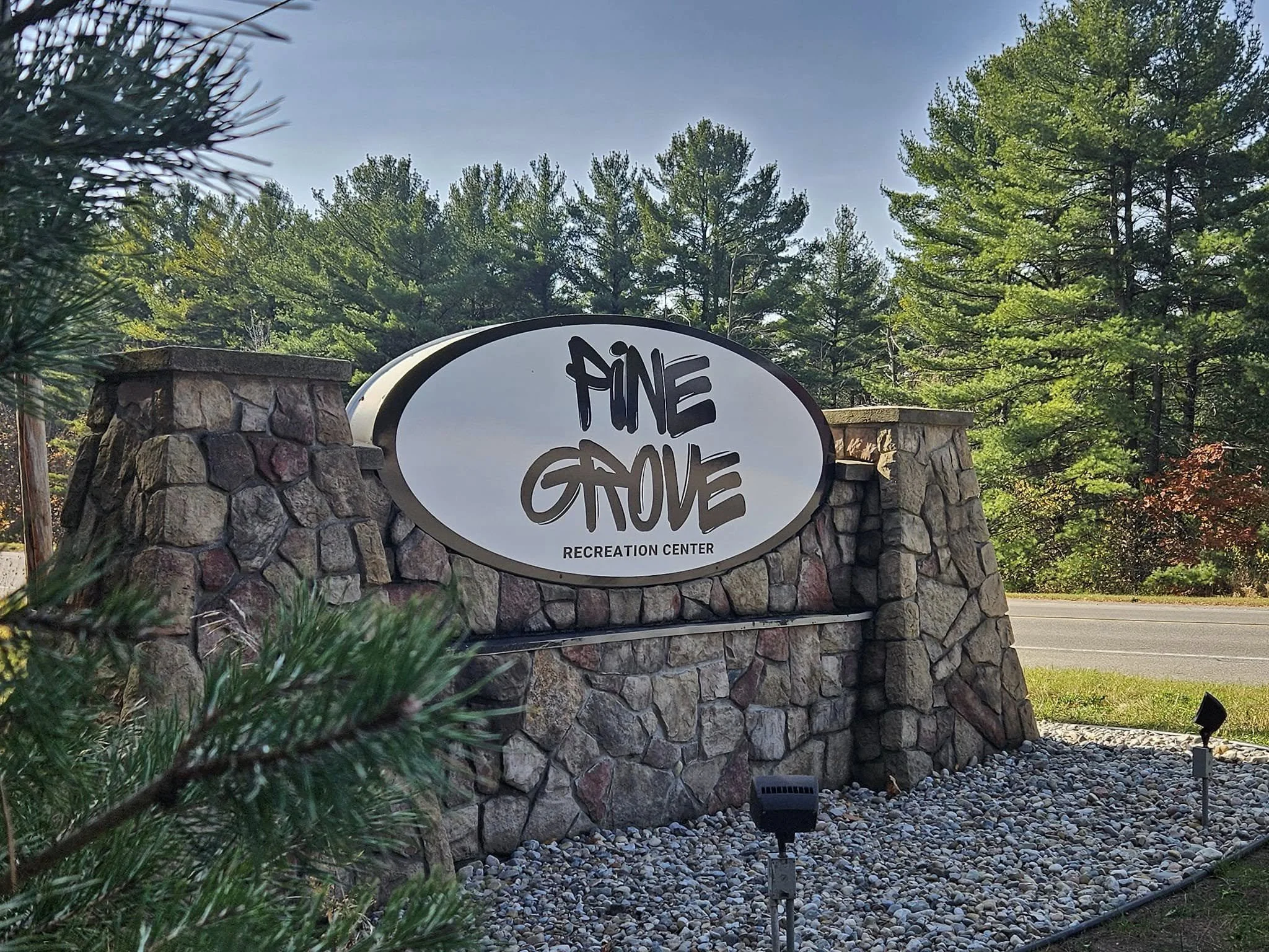 Stone wall with a sign reading "The Gove" and surrounded by trees on a clear day.