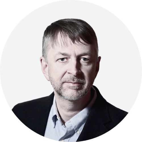 Geoff Wickstrom headshot wearing a light blue collared shirt and dark blazer.