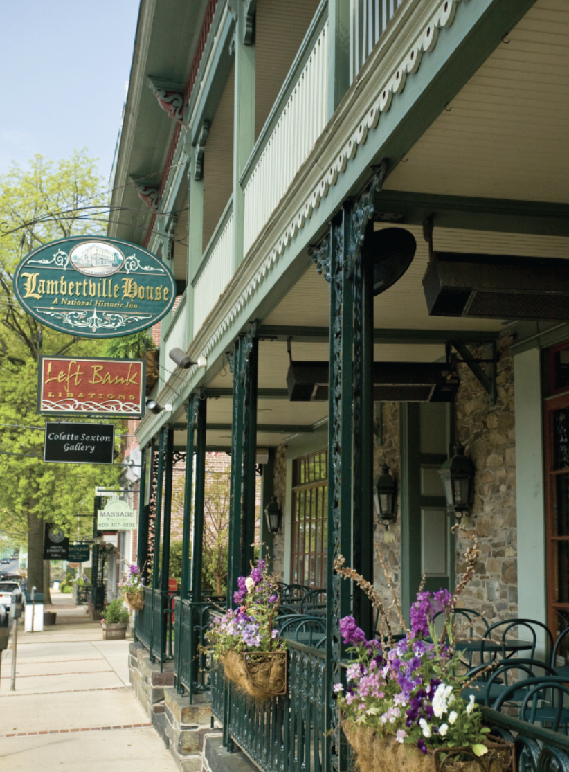 Street view of Lambertville House, a historic inn, with hanging flower baskets and restaurant signage.