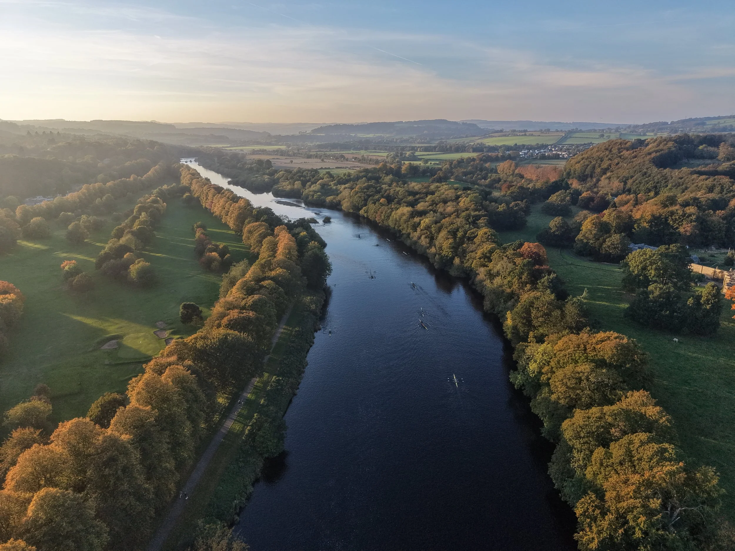 landscape view of a river with rowers on it
