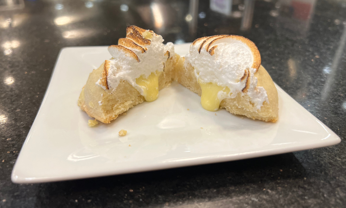 Dessert with meringue, lemon curd, and pastry on a white plate