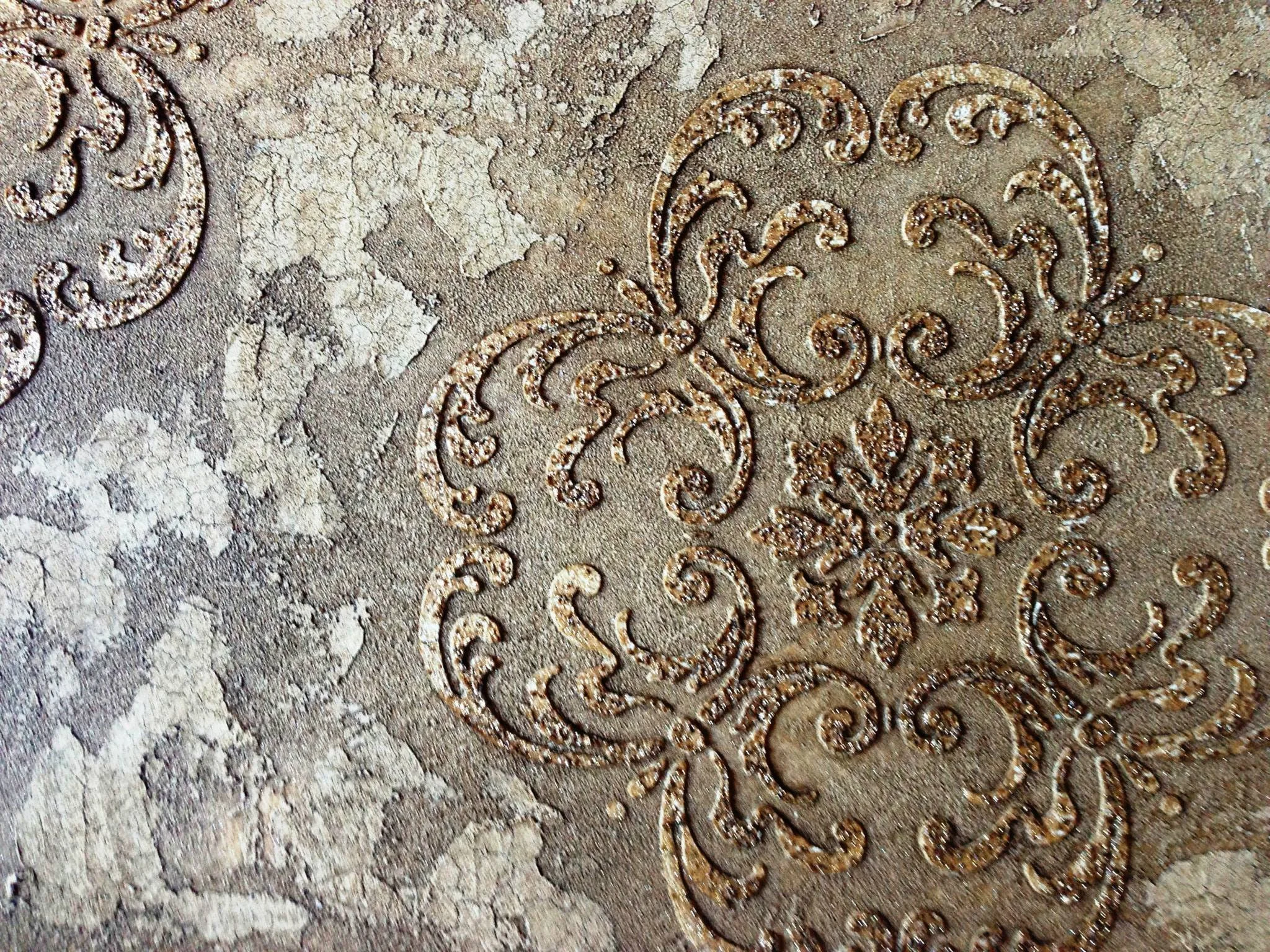 Close-up of an ornate, embossed metal or decorative surface with intricate patterns and a snowflake-shaped design in the center.