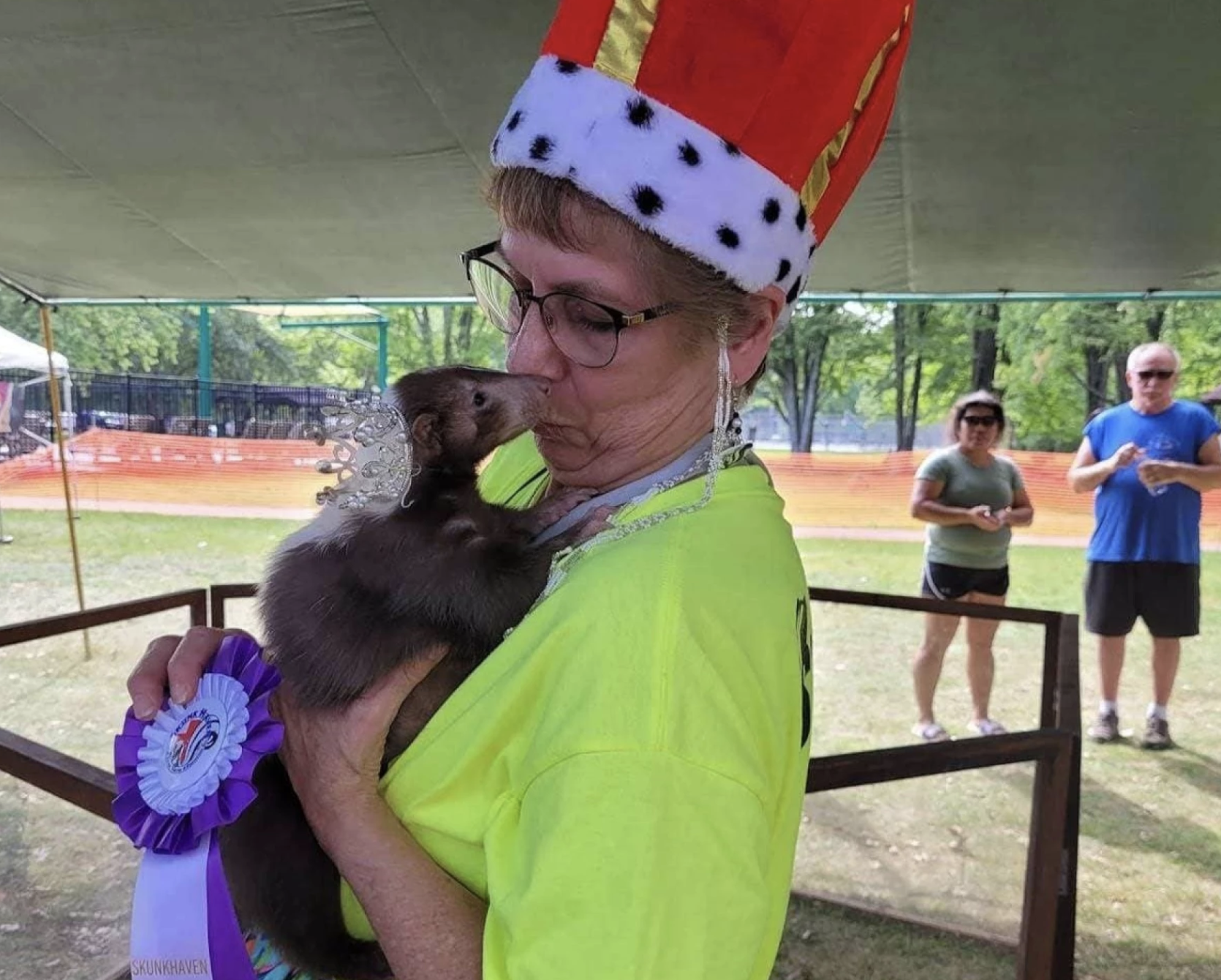 A woman in a crown holding a skunk.