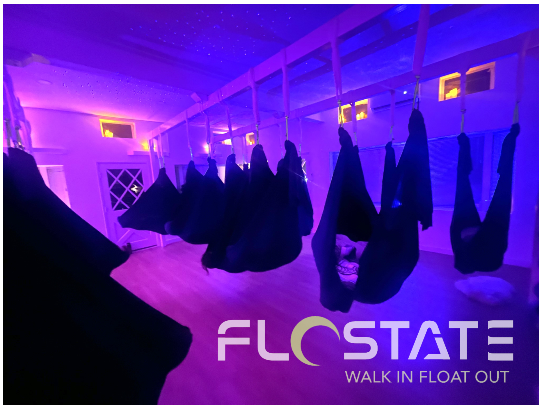 Indoor spa setting with hanging fabric drapes and lit candles