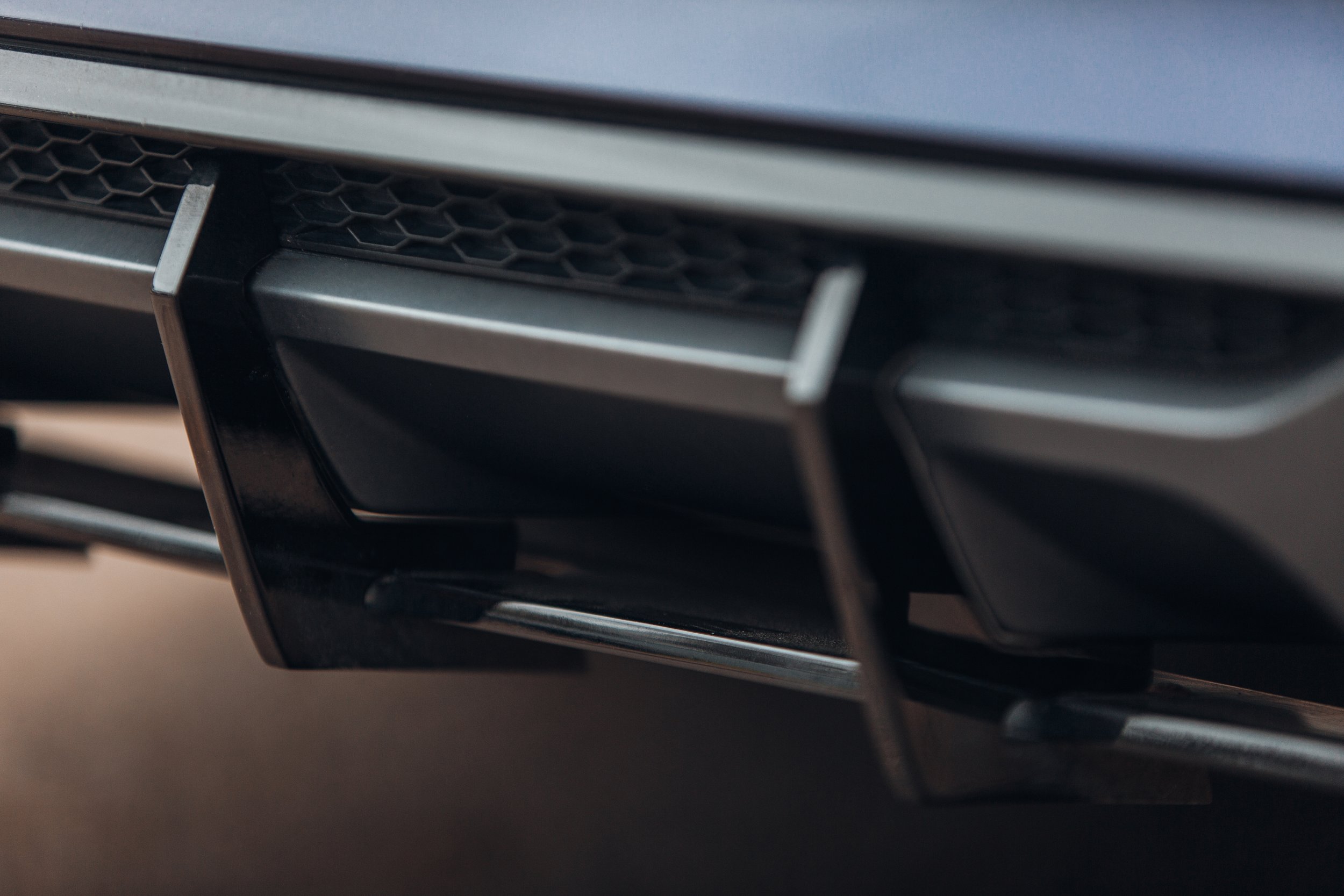 Close-up of a car's front grille with a black frame and honeycomb pattern.
