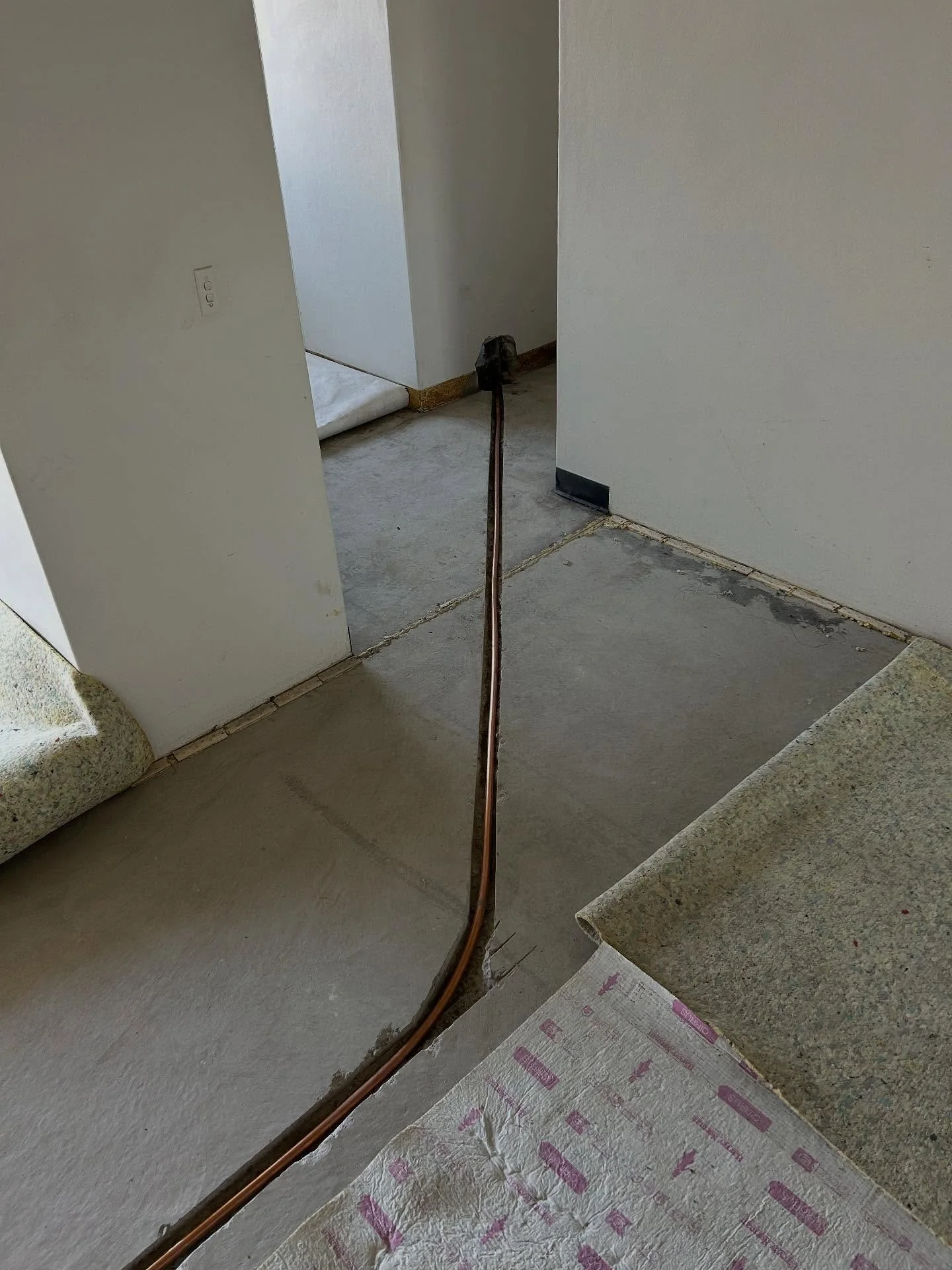 Burst pipe in the slab of the top floor unit required a reroute of new pipework, with a cold water bypass chased into the slab