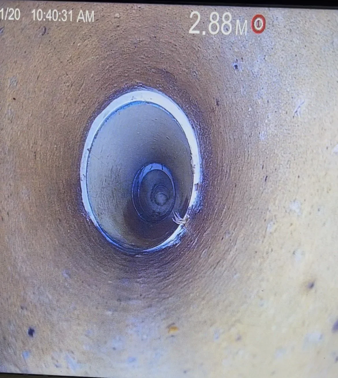 Close-up of a pipe or tunnel interior with a circular opening, showing the inner surface and some debris inside. The digital overlay shows a measurement of 2.88 meters and the time 10:40:31 AM.