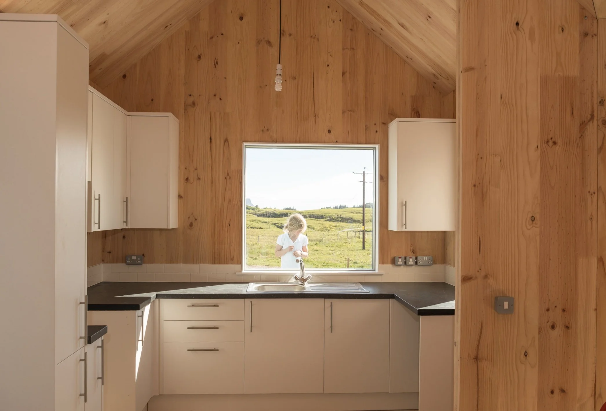 child in kitchen window, cross laminated timber interior
