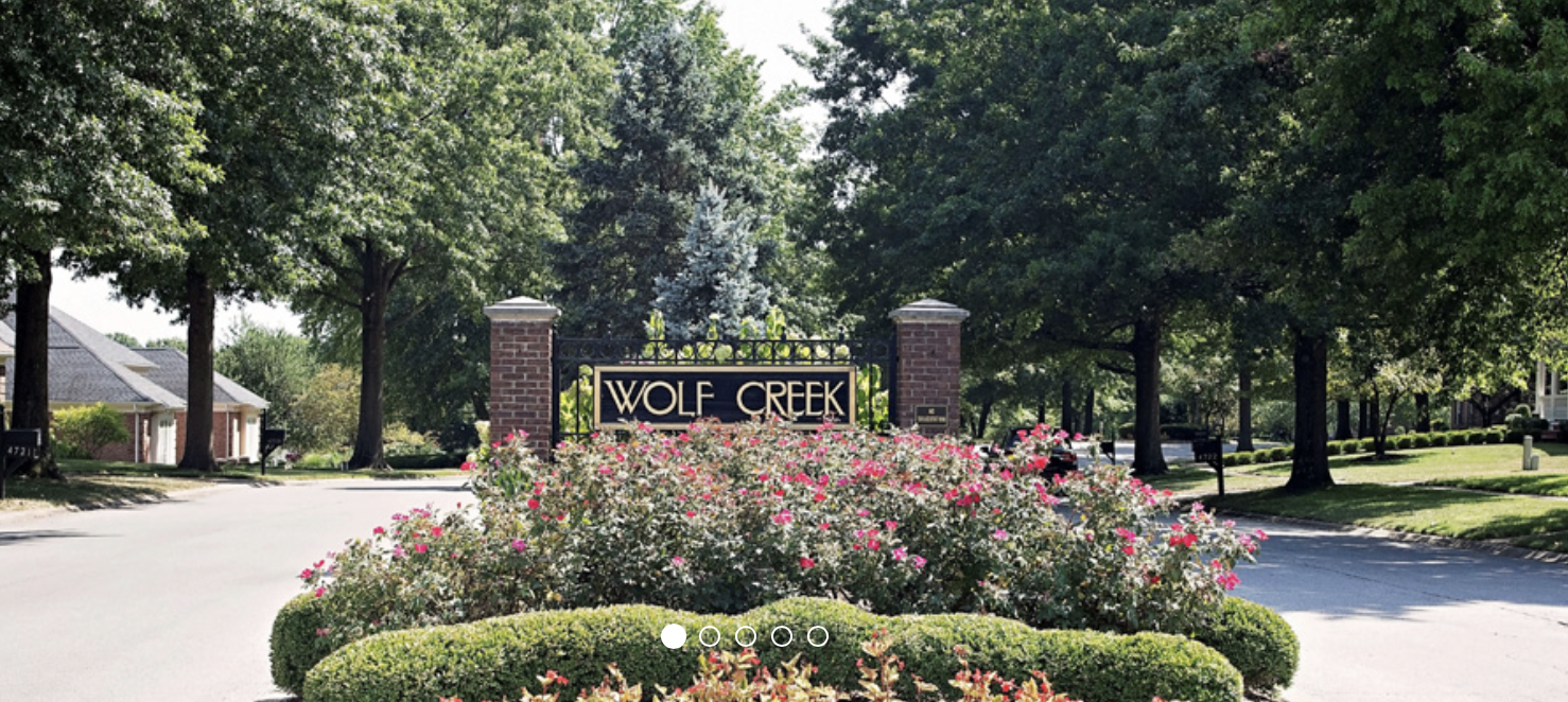 Entrance sign for the Wolf Creek neighborhood in Louisville, Kentucky, surrounded by mature landscaping and tree-lined residential streets.