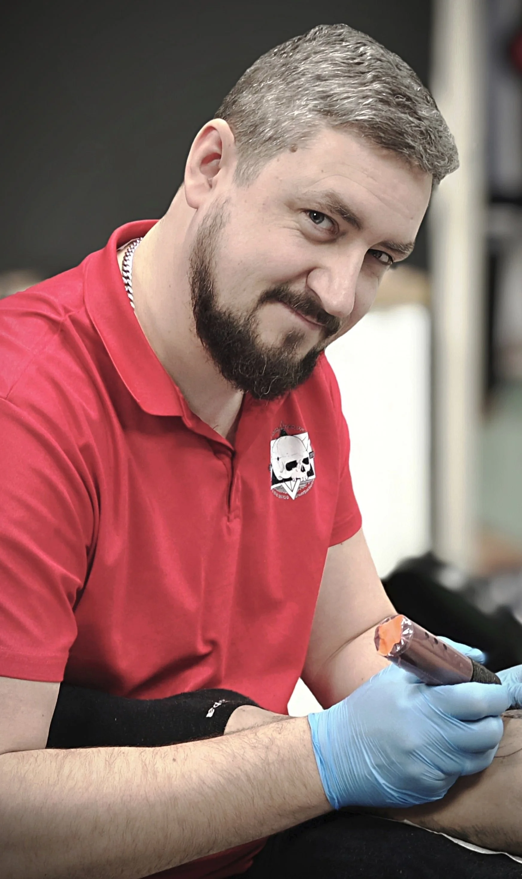 Tatuiruočių meistras tatuiruoja kliento ranką.