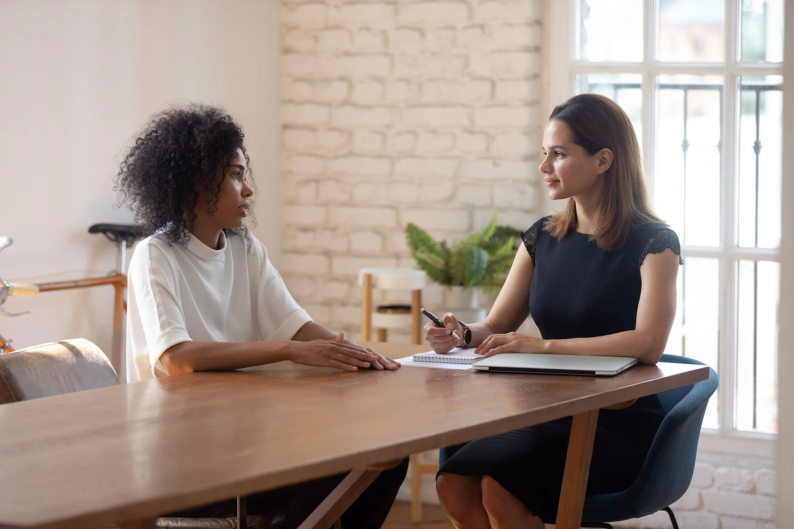 woman in black fress mentoring another woman