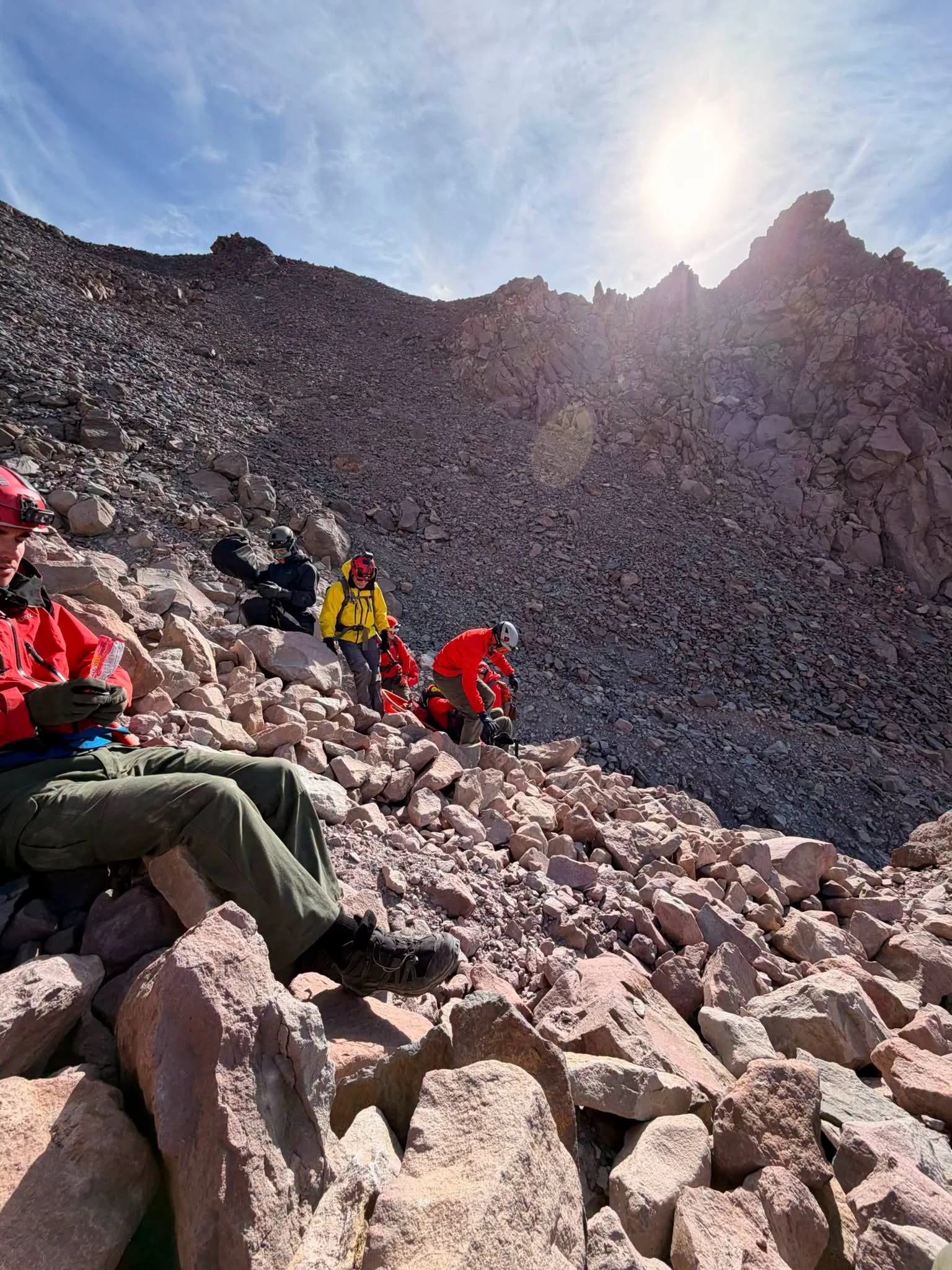   Challenging Mount Shasta Rescue:  Search and rescue personnel work across loose volcanic rock during the effort to evacuate an injured climber from Whitney Glacier. Crews faced steep slopes and rockfall hazards while moving the climber toward a hel