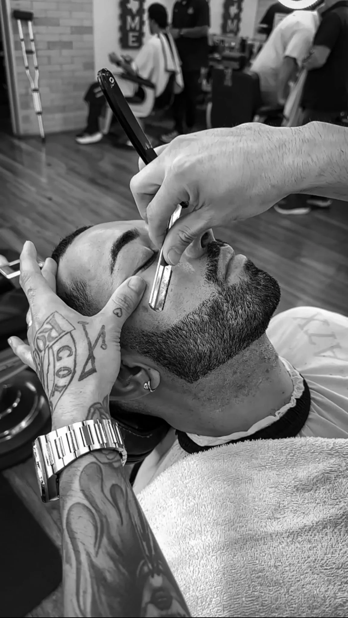 Barber performing beard lineup with straight razor in Austin by Reiko Rodriquez