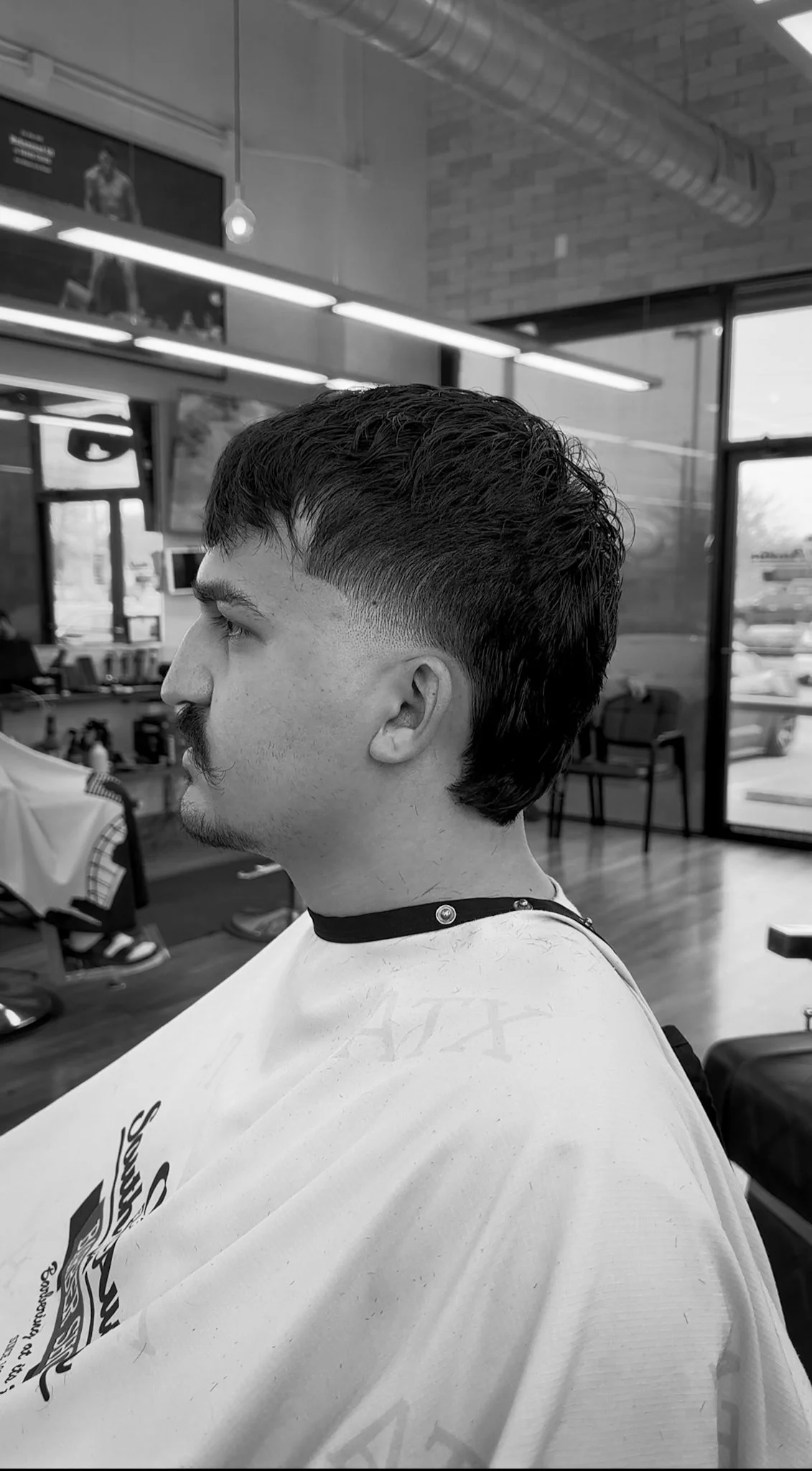 Men’s fade haircut in Austin by barber Reiko Rodriquez with clean side profile