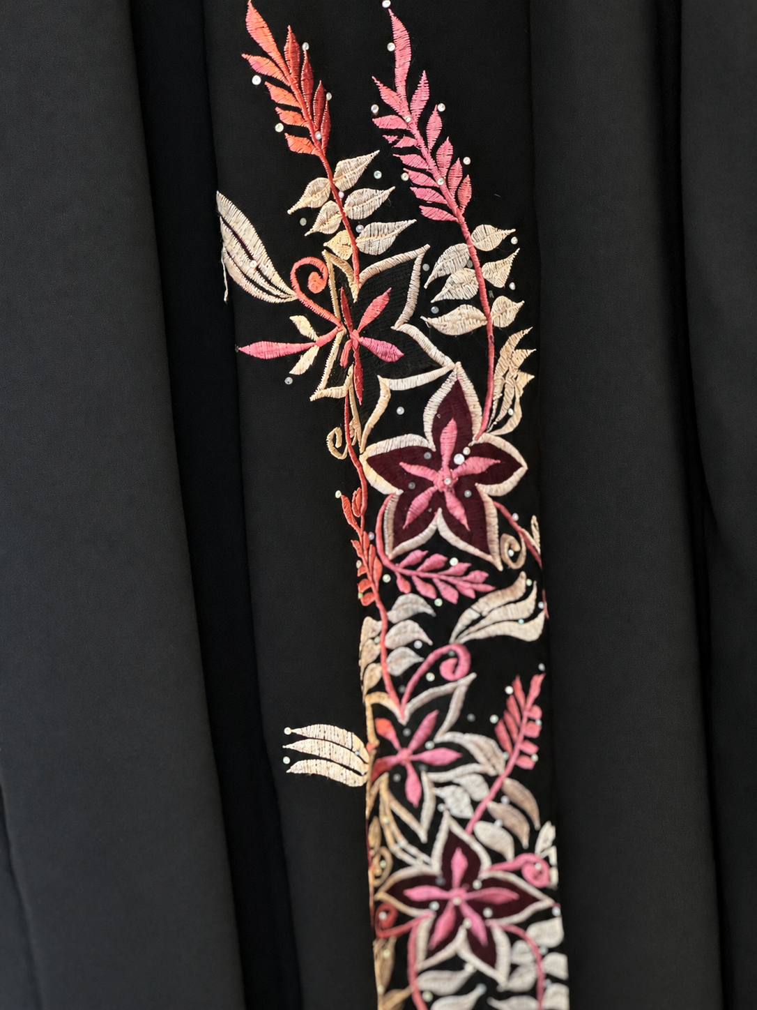 Intricate Floral Embroidery on Black Fabric.png