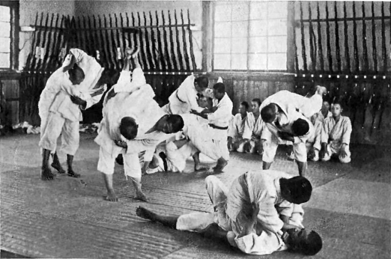 Junge Judoka beim Judo-Training im Gi mit Kampf- und Übungssituationen auf der Matte