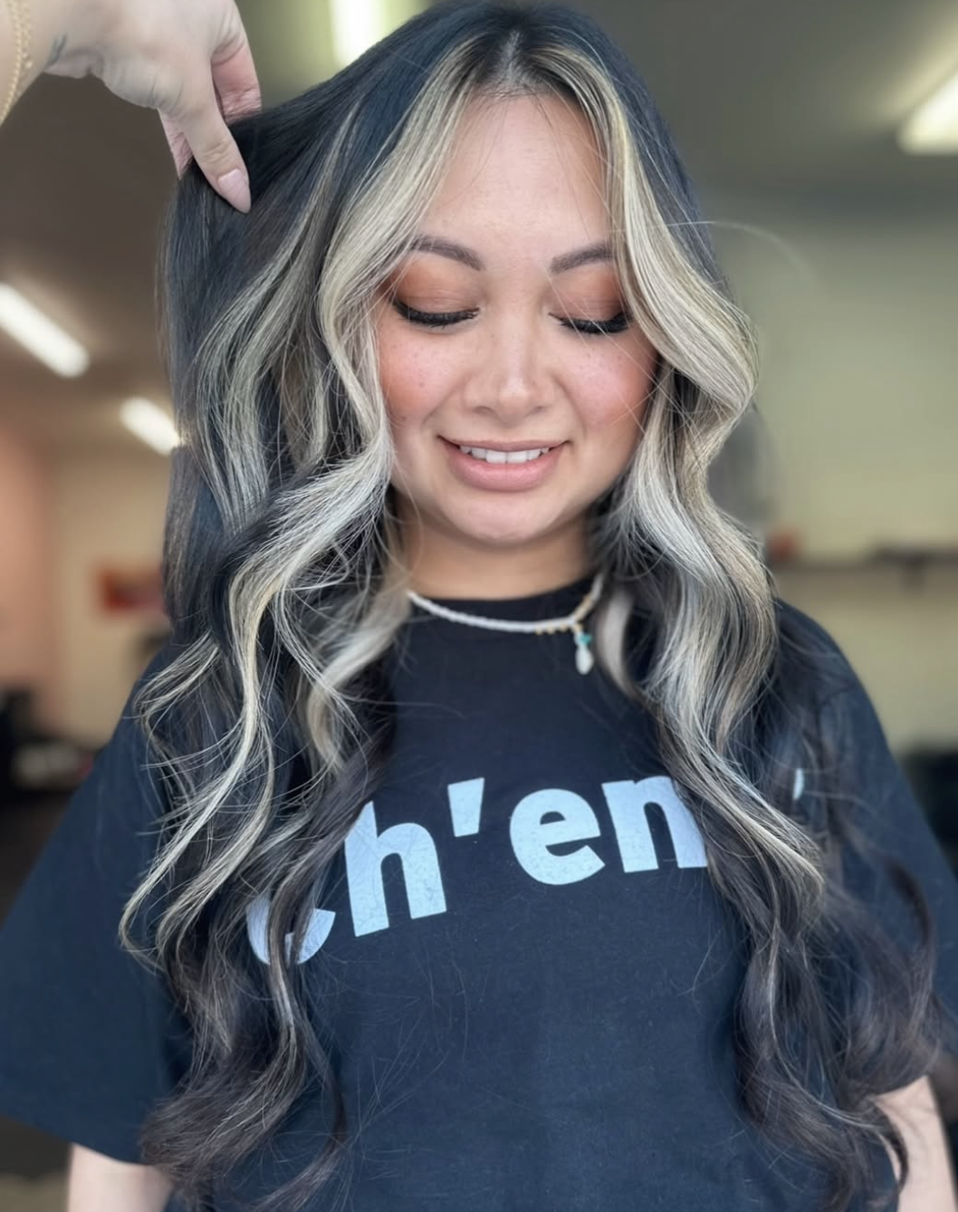 Woman with dark hair but a few light blonde highlights just in the very front