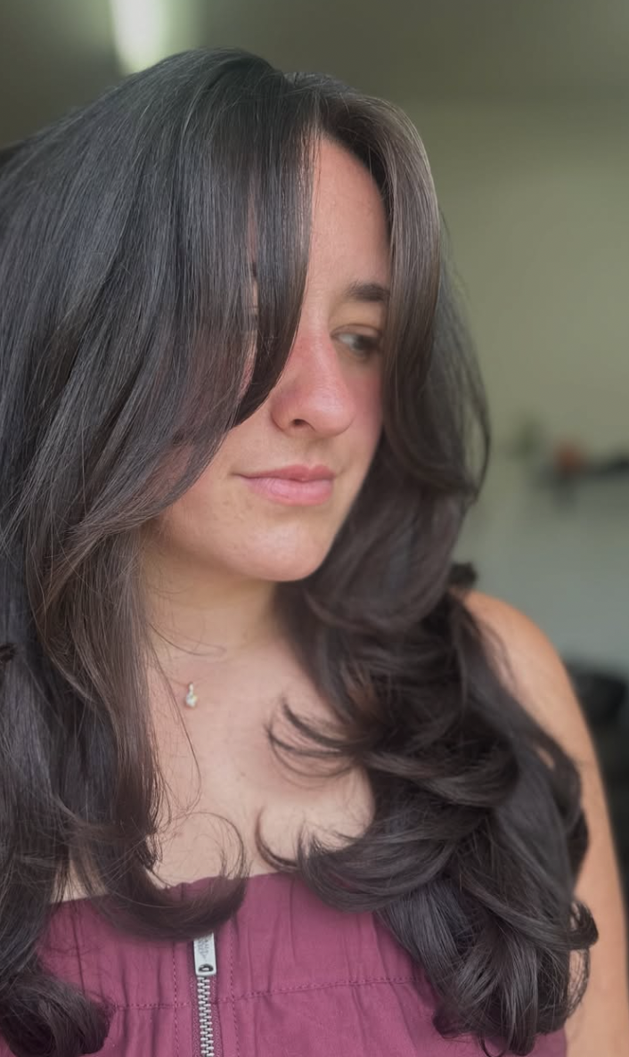 Woman with dark long hair cut in layers