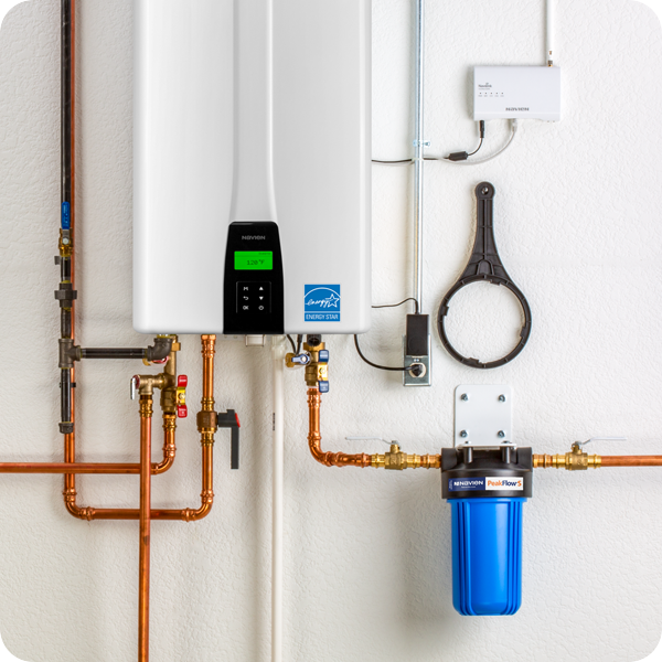 Water heater with copper piping and filtration system mounted on a white wall.