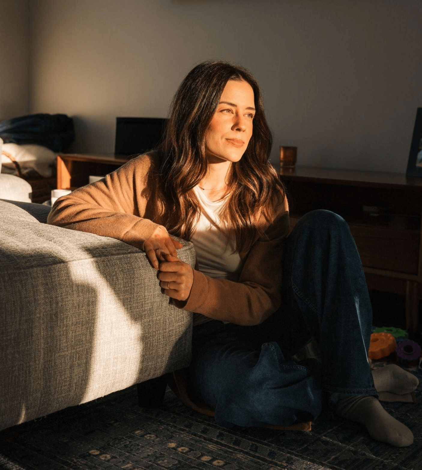 Woman sitting quietly in a reflective moment, representing the pause to reconnect with yourself.