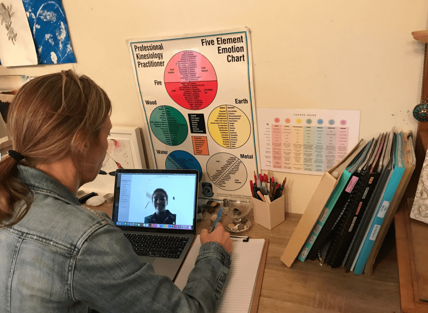 Nicole Makhudu guiding a trauma-informed online session at her desk, offering calm, somatic-based support through Luminousness