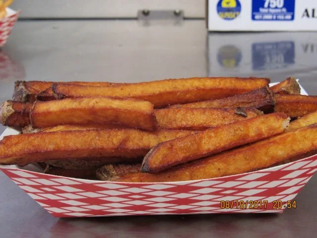 A basket of cooked French fries on a table.
