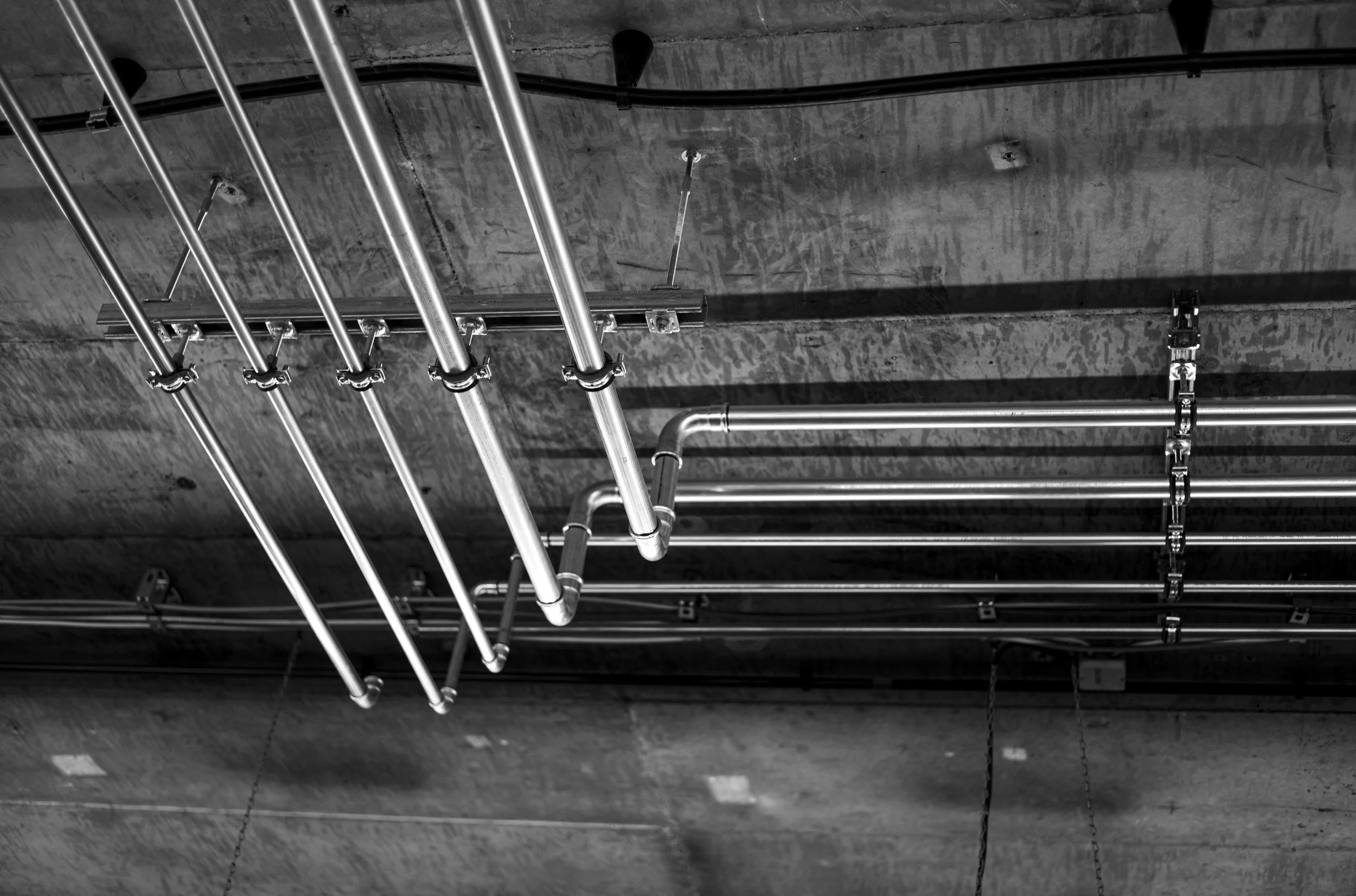 Ceiling with metal pipes and ducts in an industrial or commercial building.