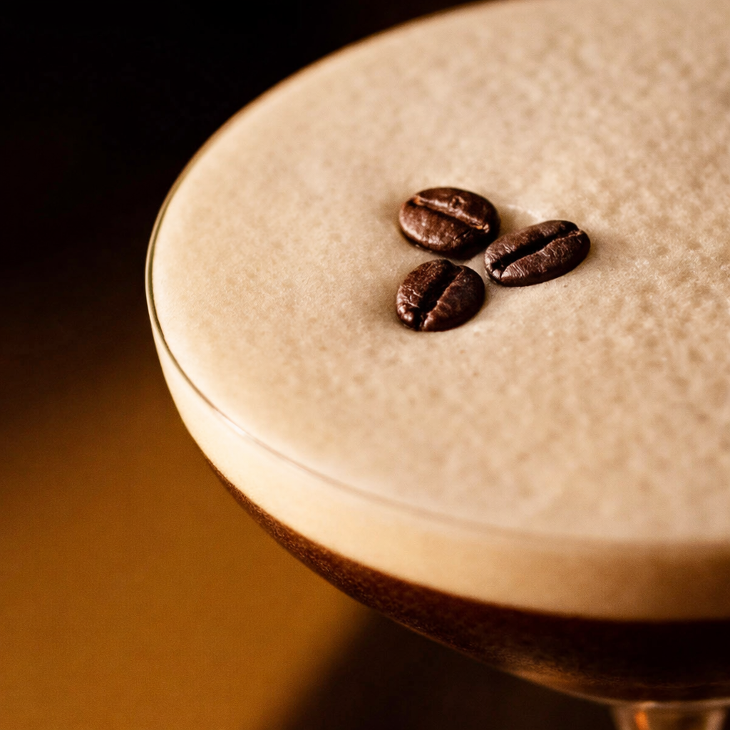Close-up of a coffee drink with three coffee beans on top of the foam.