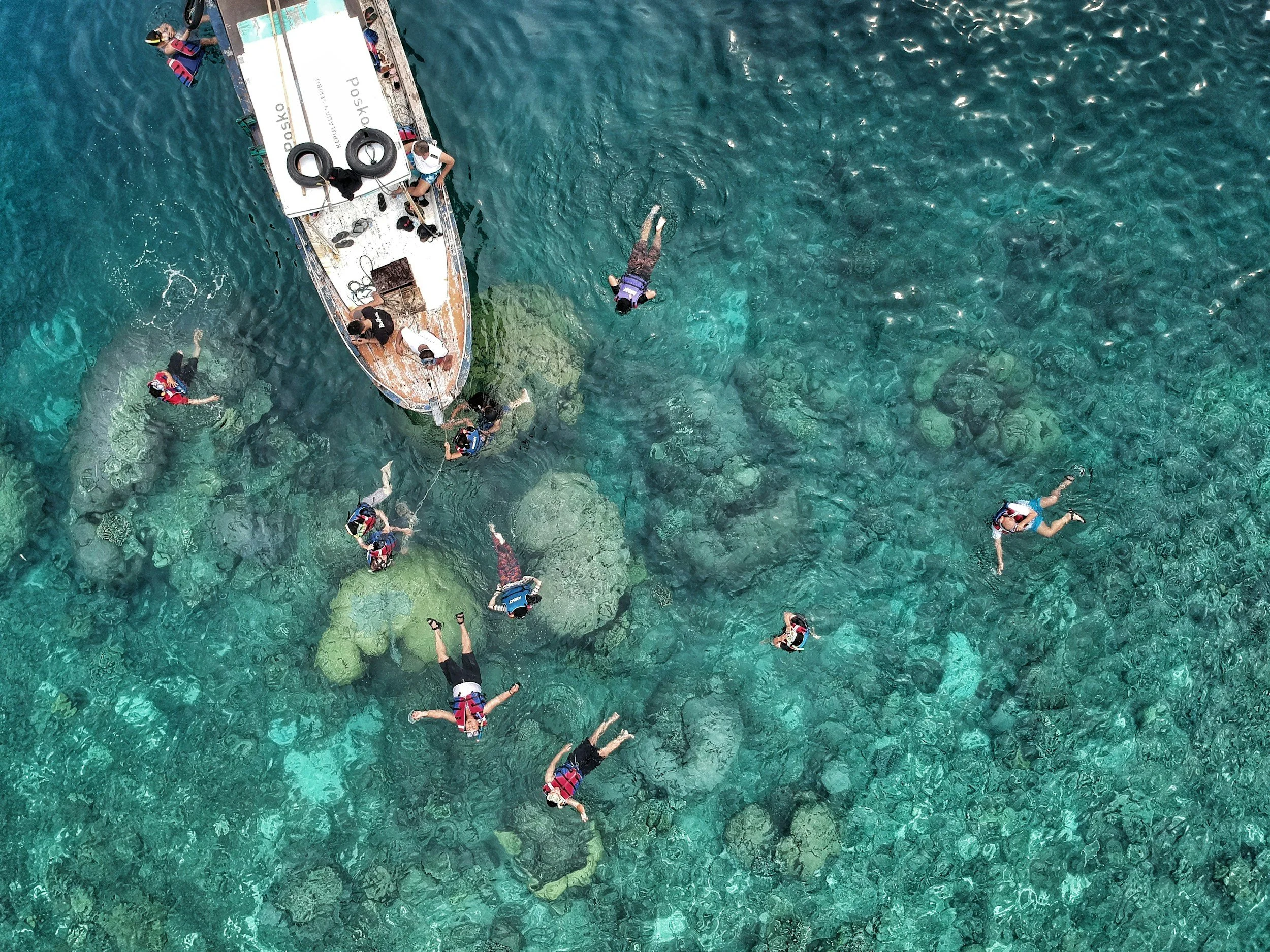 snorkelers of around a boat off Gold coast having fun swimming around the coral reef