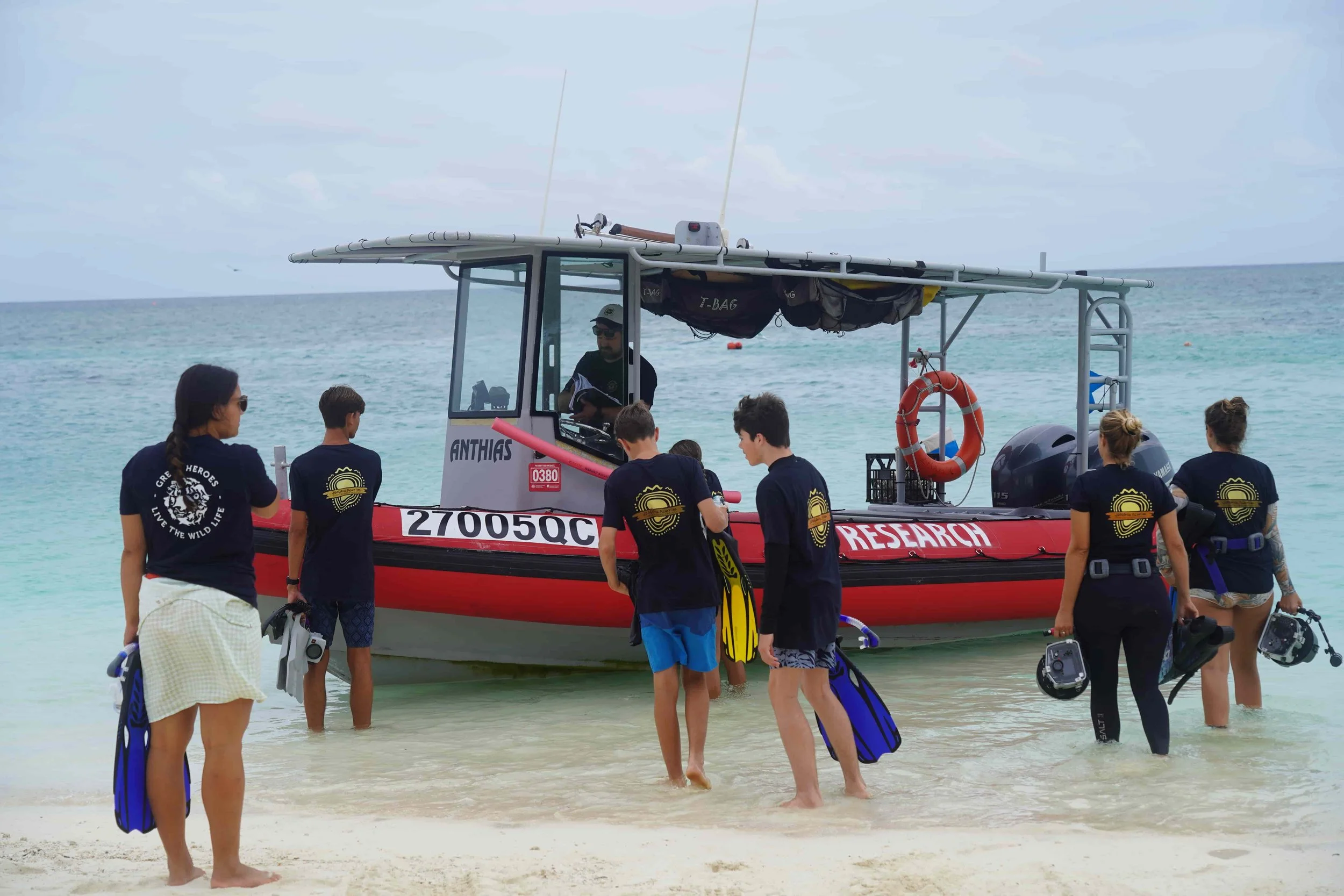 young researchers boarding vessel or boat on a beach. they are part of green heroes