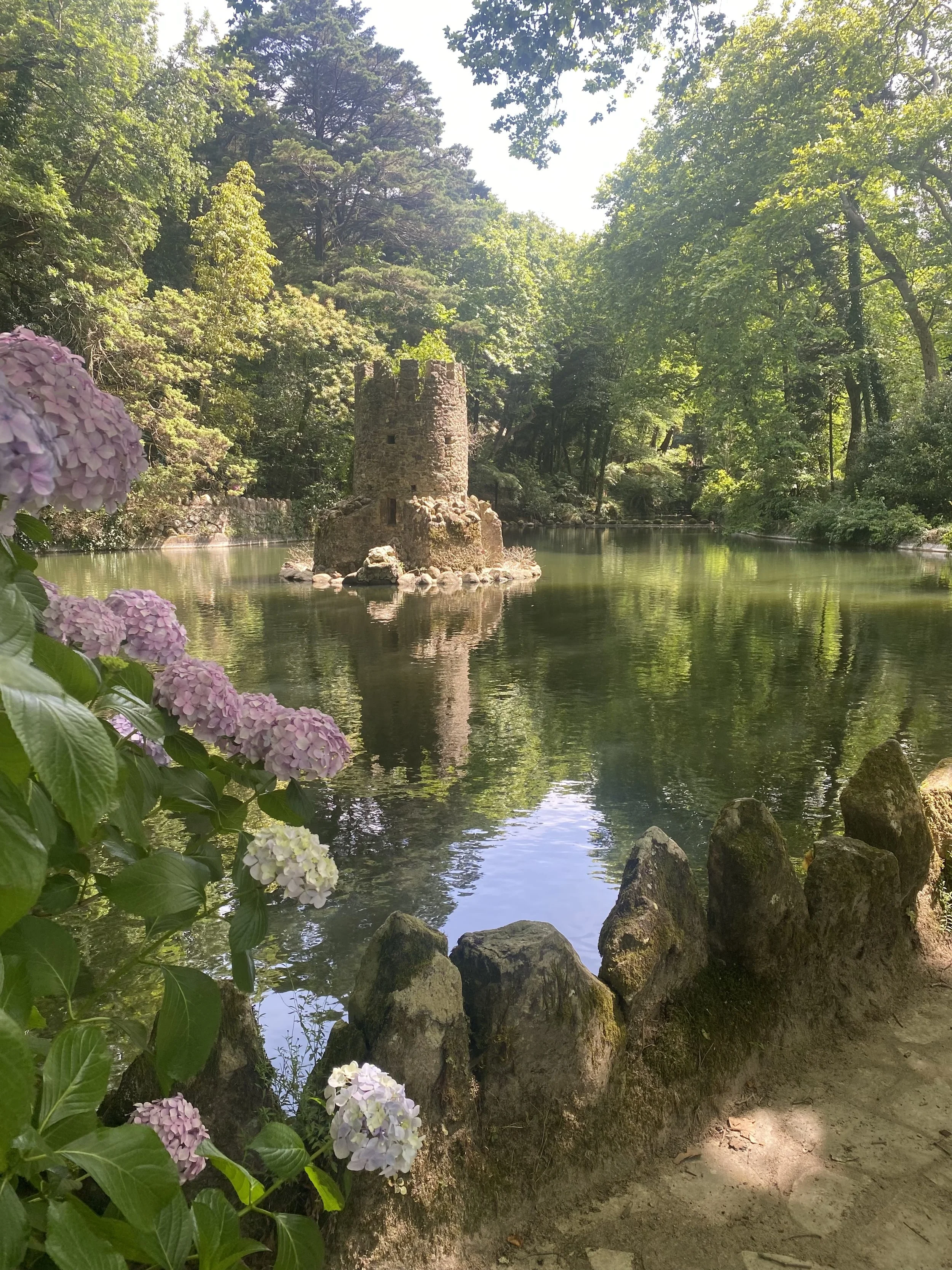 Scenic landscape of mountains, a lake, and rolling grassy hills under cloudy sky.