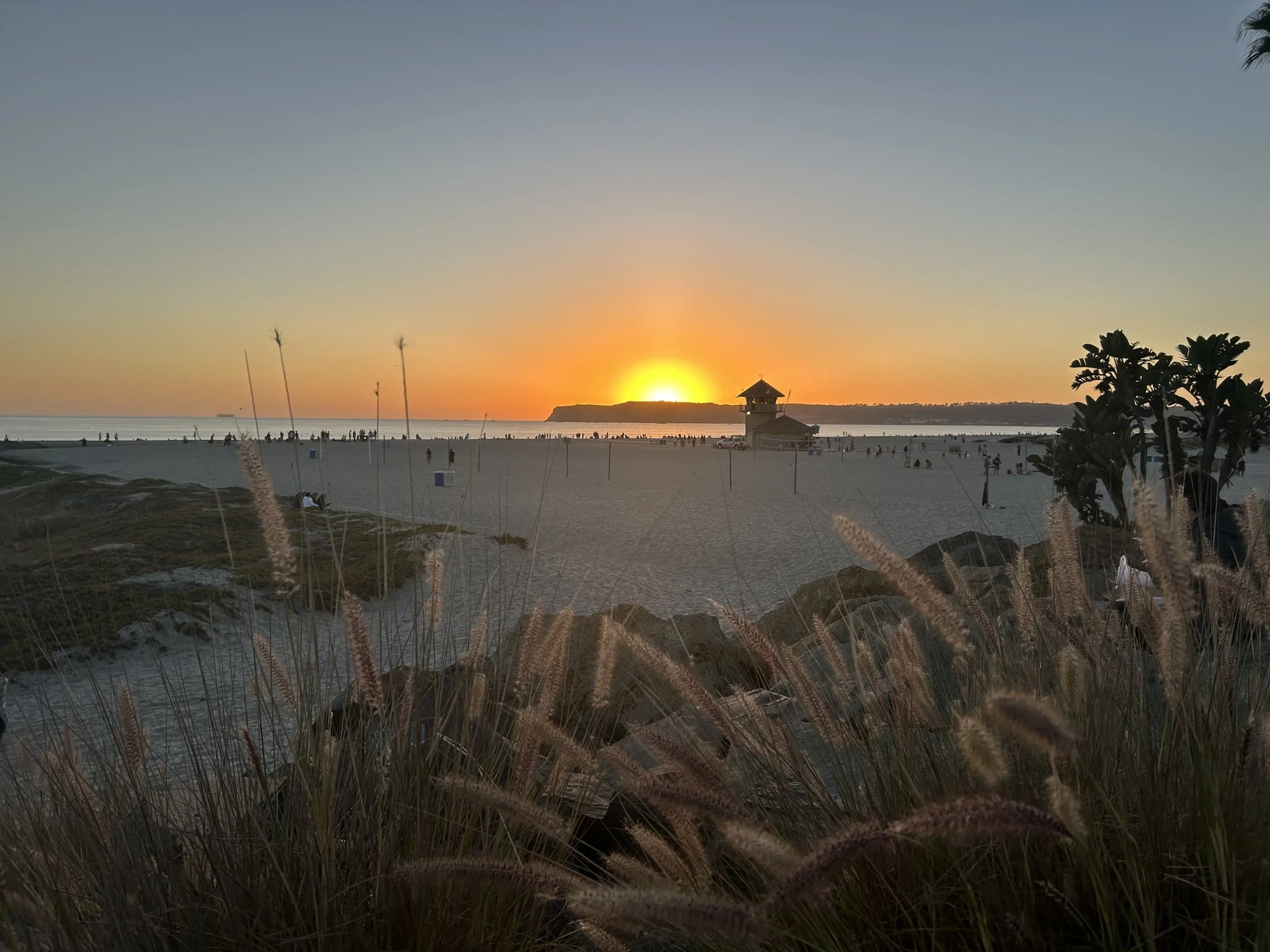 Scenic view of snow-capped mountains in the background with a small modern building on a hill in the foreground.